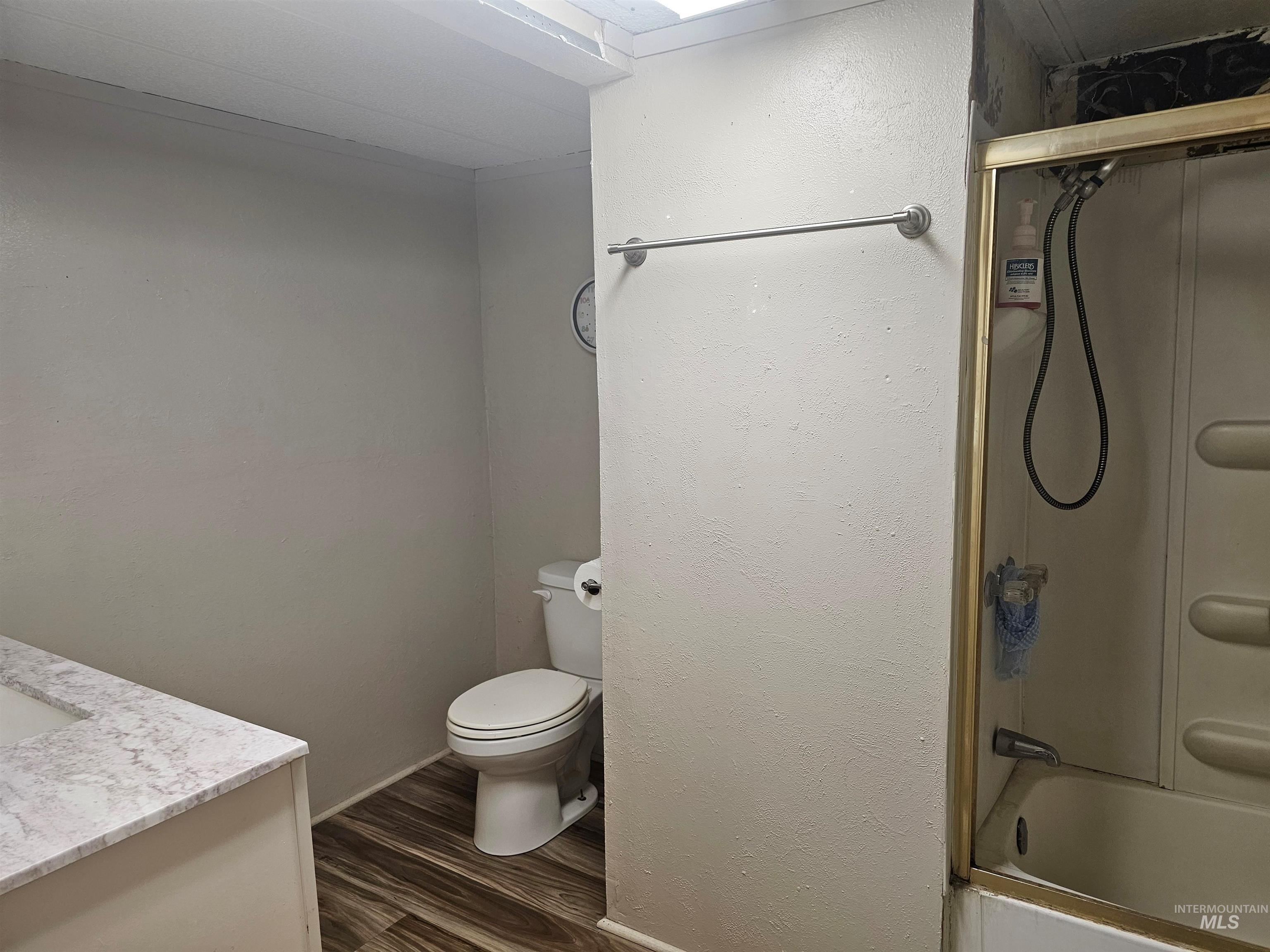 Bathroom with vanity, dark wood-type flooring, and bathing tub / shower combination