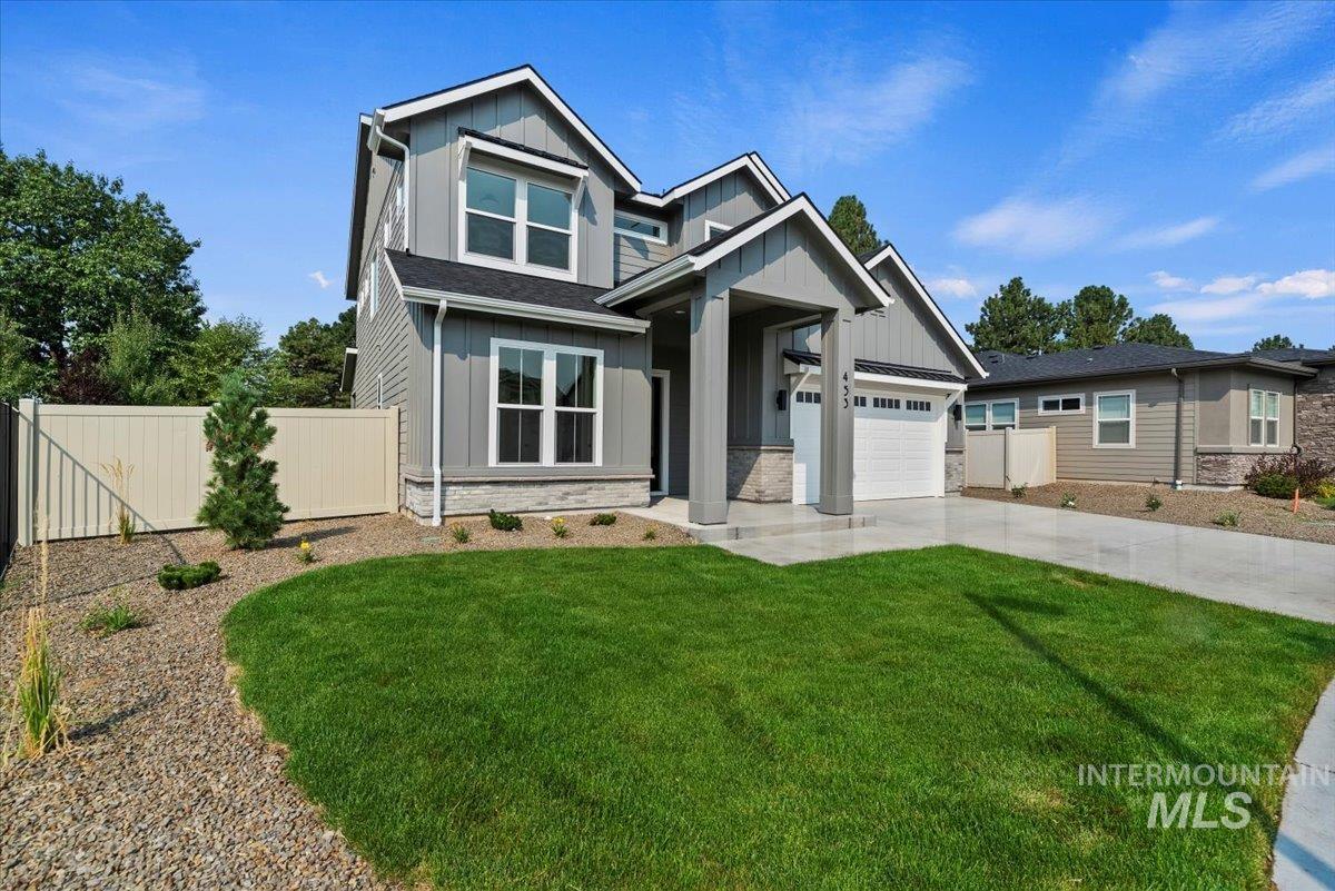 View of front of house with board and batten siding, concrete driveway, stone siding, and an attached garage