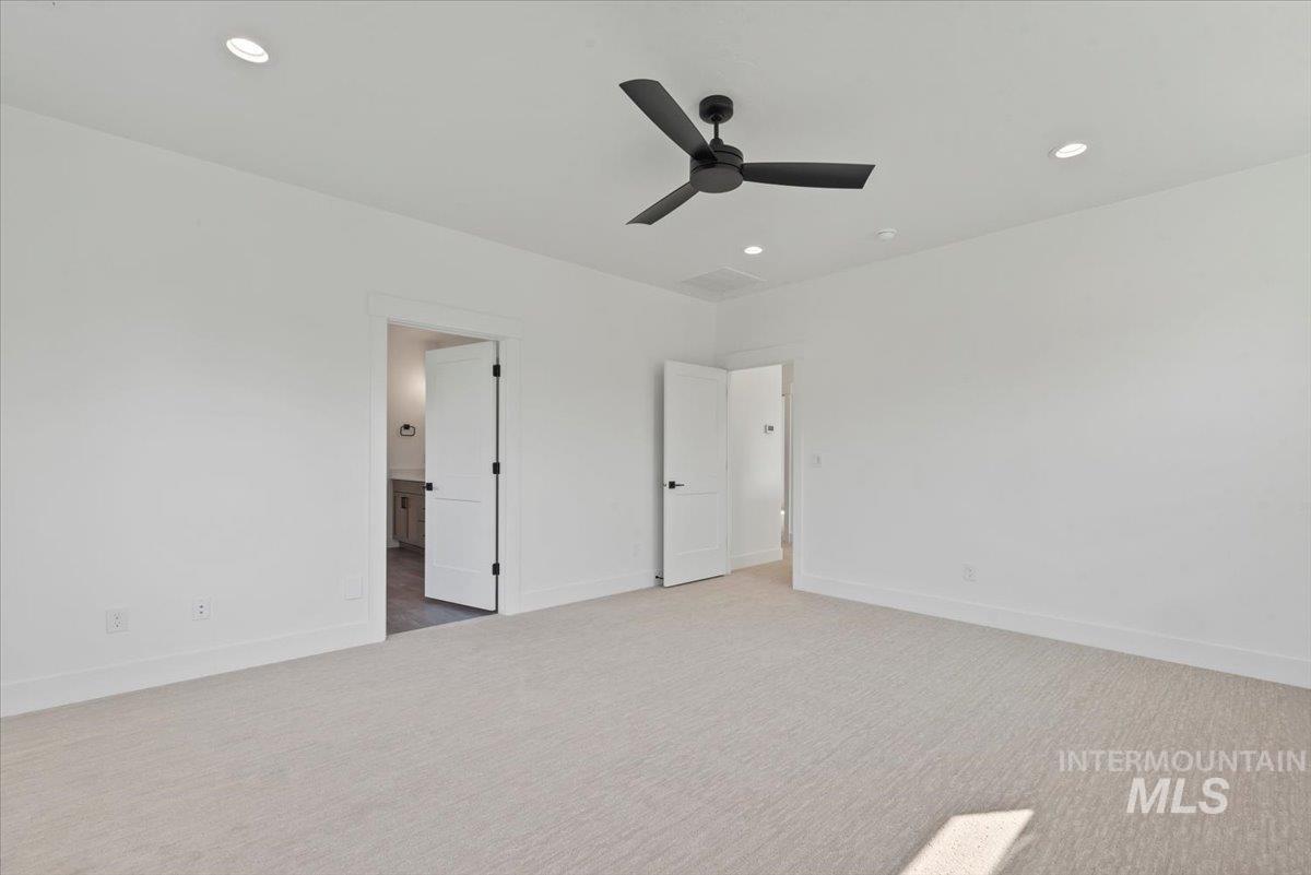 Unfurnished bedroom featuring carpet floors, recessed lighting, ceiling fan, and connected bathroom