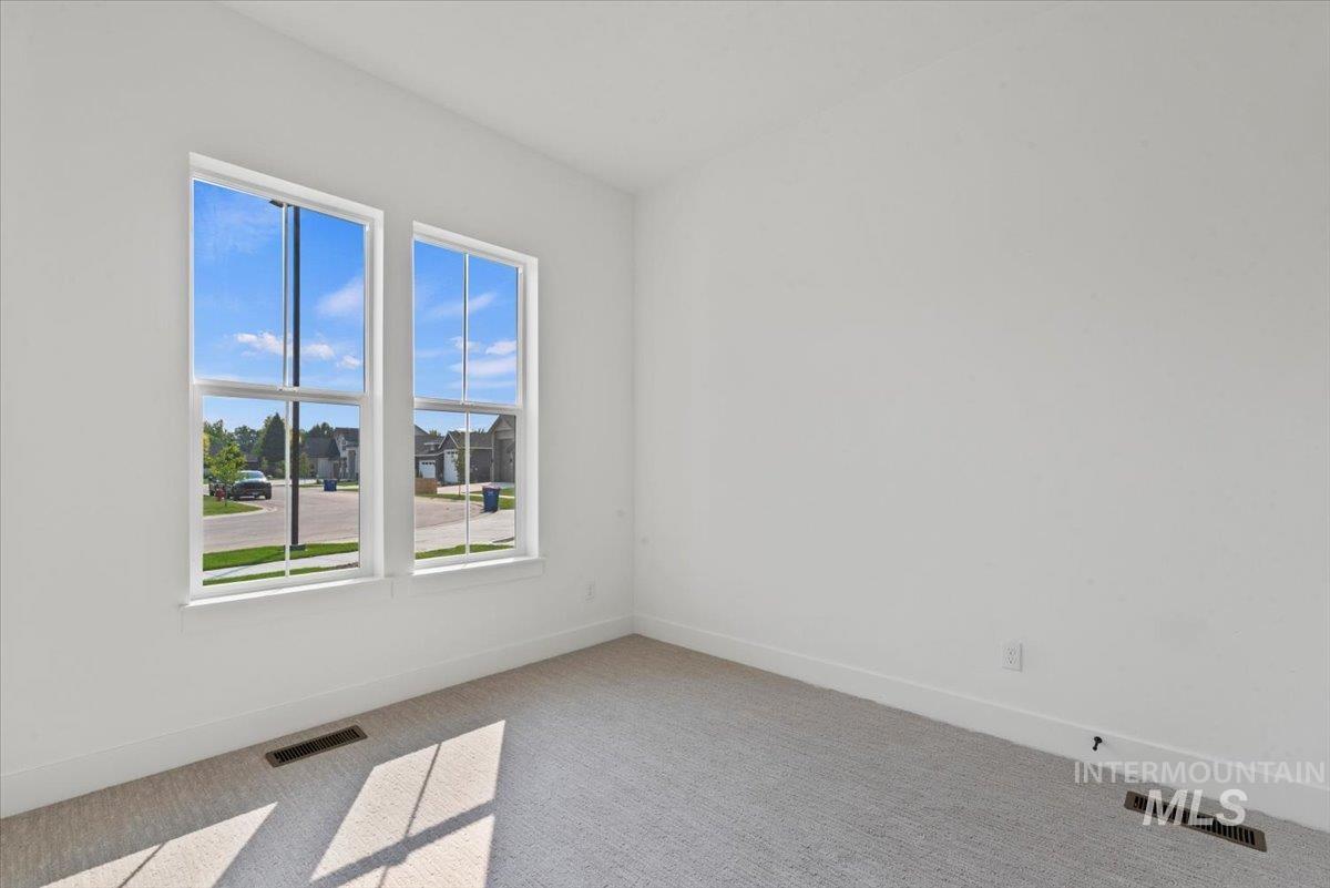 Carpeted spare room with baseboards