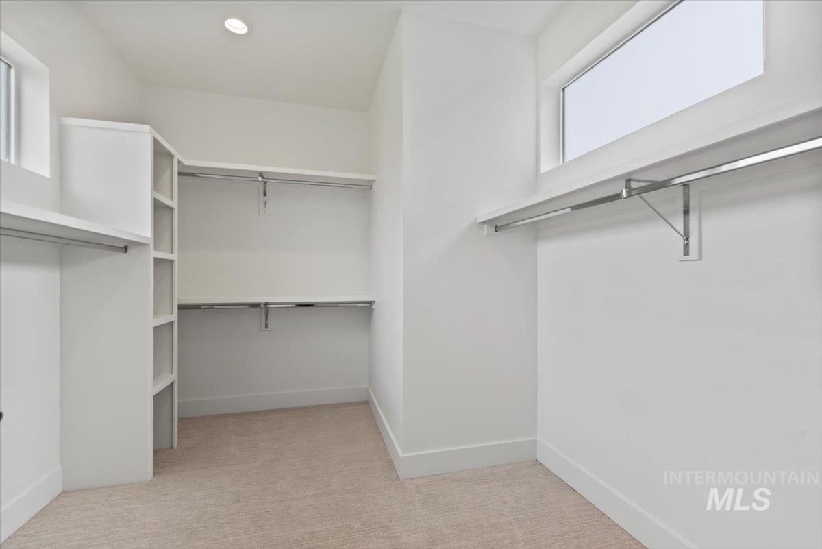 Walk in closet with light carpet