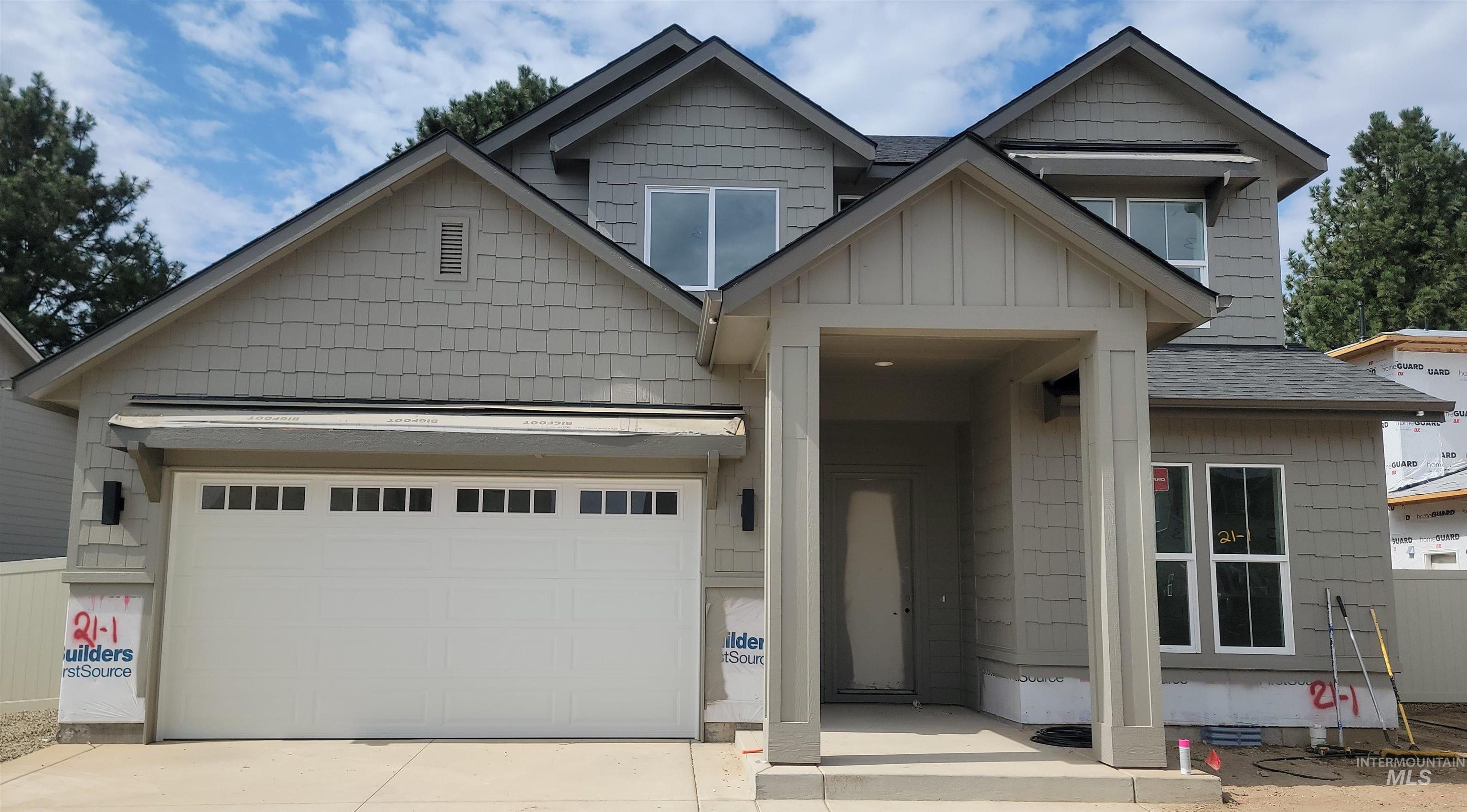 Craftsman-style house with driveway, a garage, a shingled roof, and board and batten siding