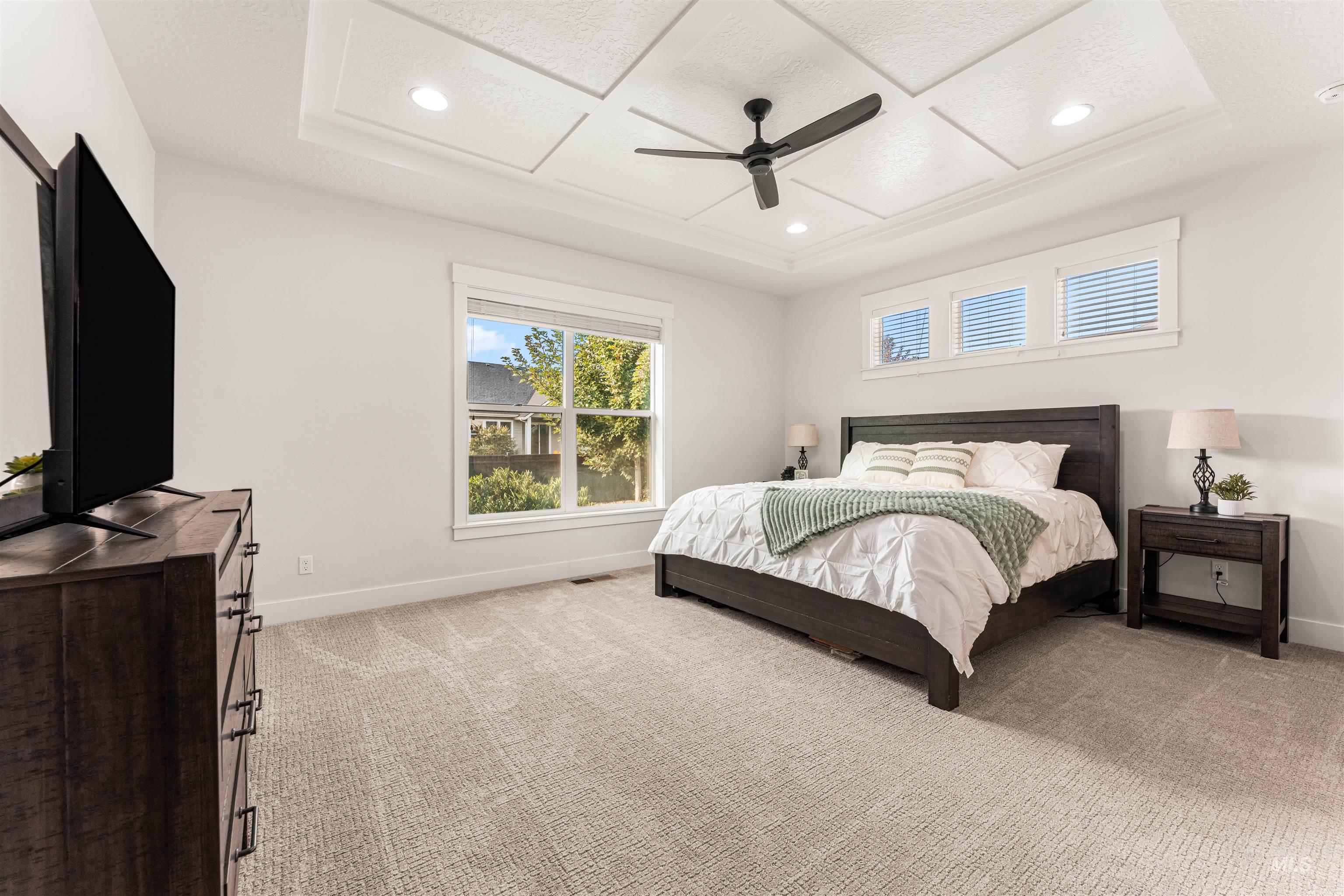 Primary Bedroom with recessed lighting, coffered ceiling, and a ceiling fan.