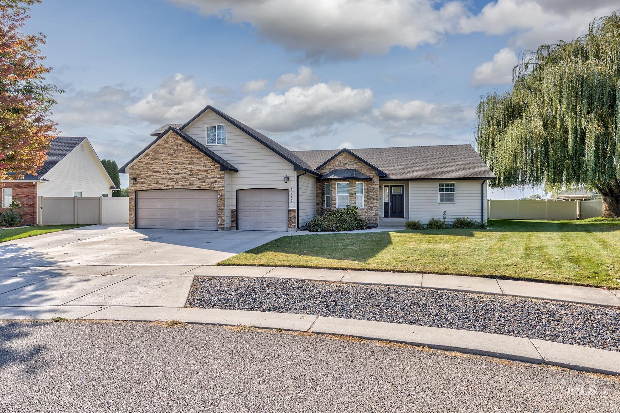 View of front of house featuring driveway, stone siding, an attached garage, and roof with shingles