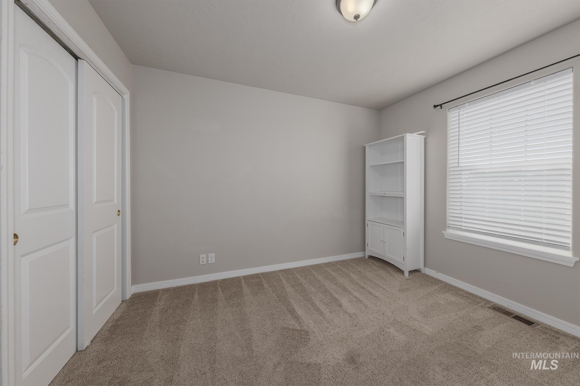 bedroom featuring light colored carpet and a closet