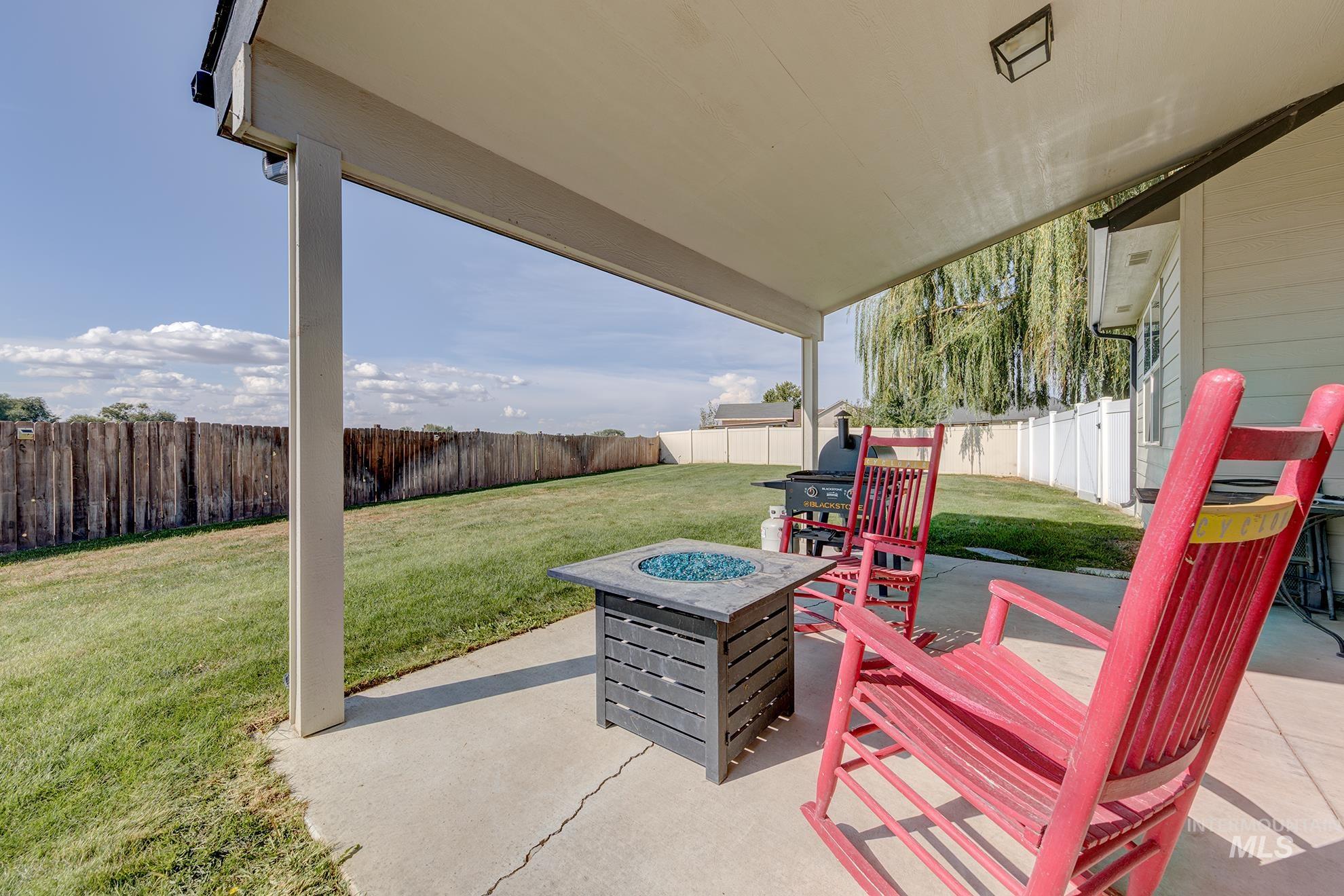 Fenced backyard featuring an outdoor fire pit and a patio area