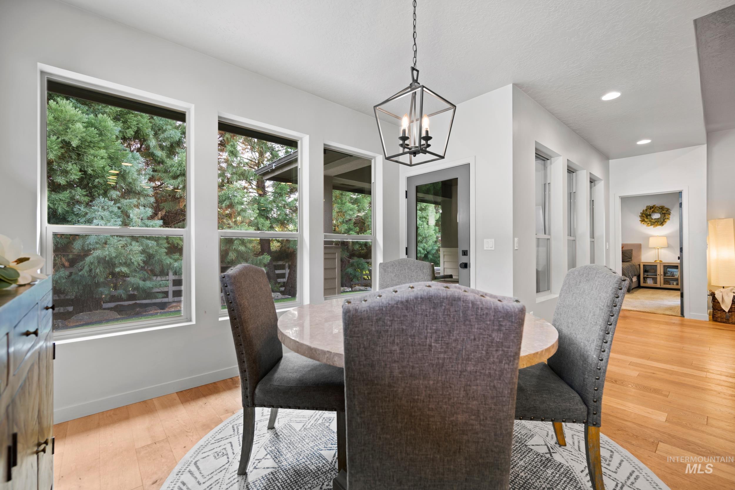 Dining area featuring light wood-style flooring, recessed lighting, and a chandelier