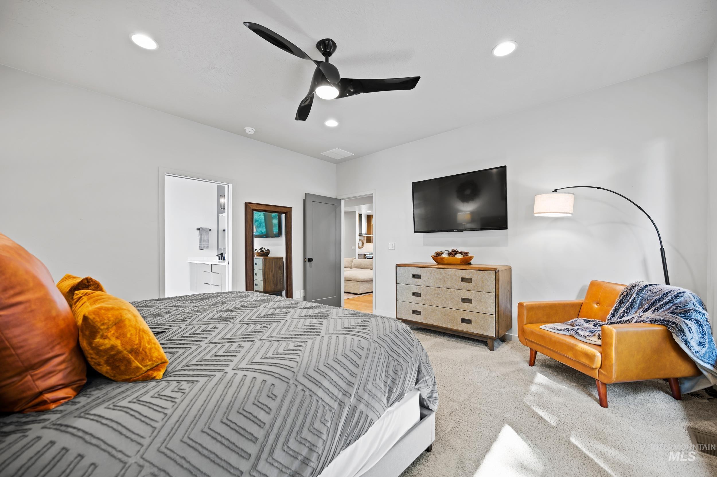 Bedroom featuring light carpet, recessed lighting, a ceiling fan, and ensuite bath