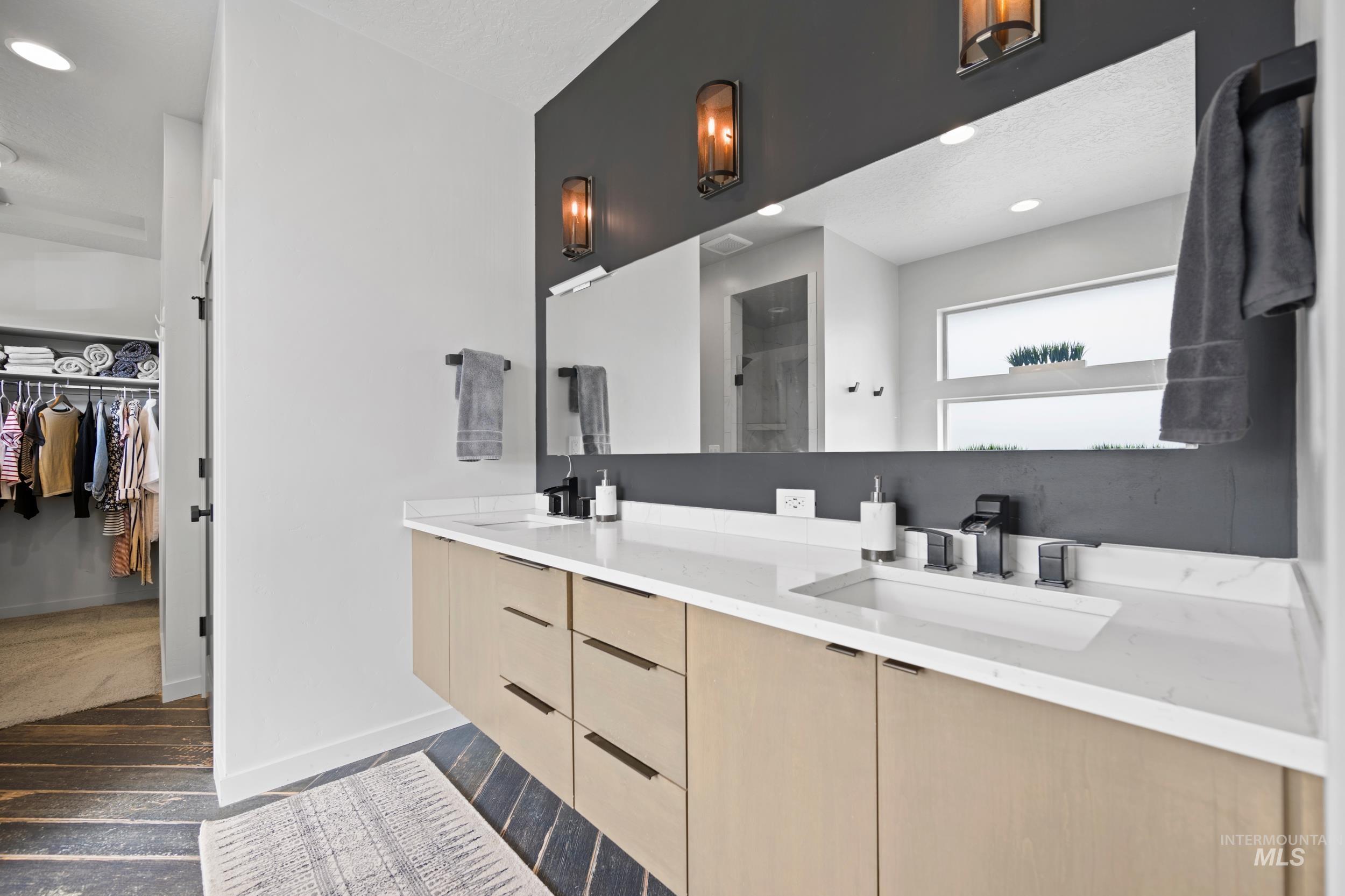 Full bath featuring a spacious closet, dark wood-style floors, double vanity, recessed lighting, and a shower stall