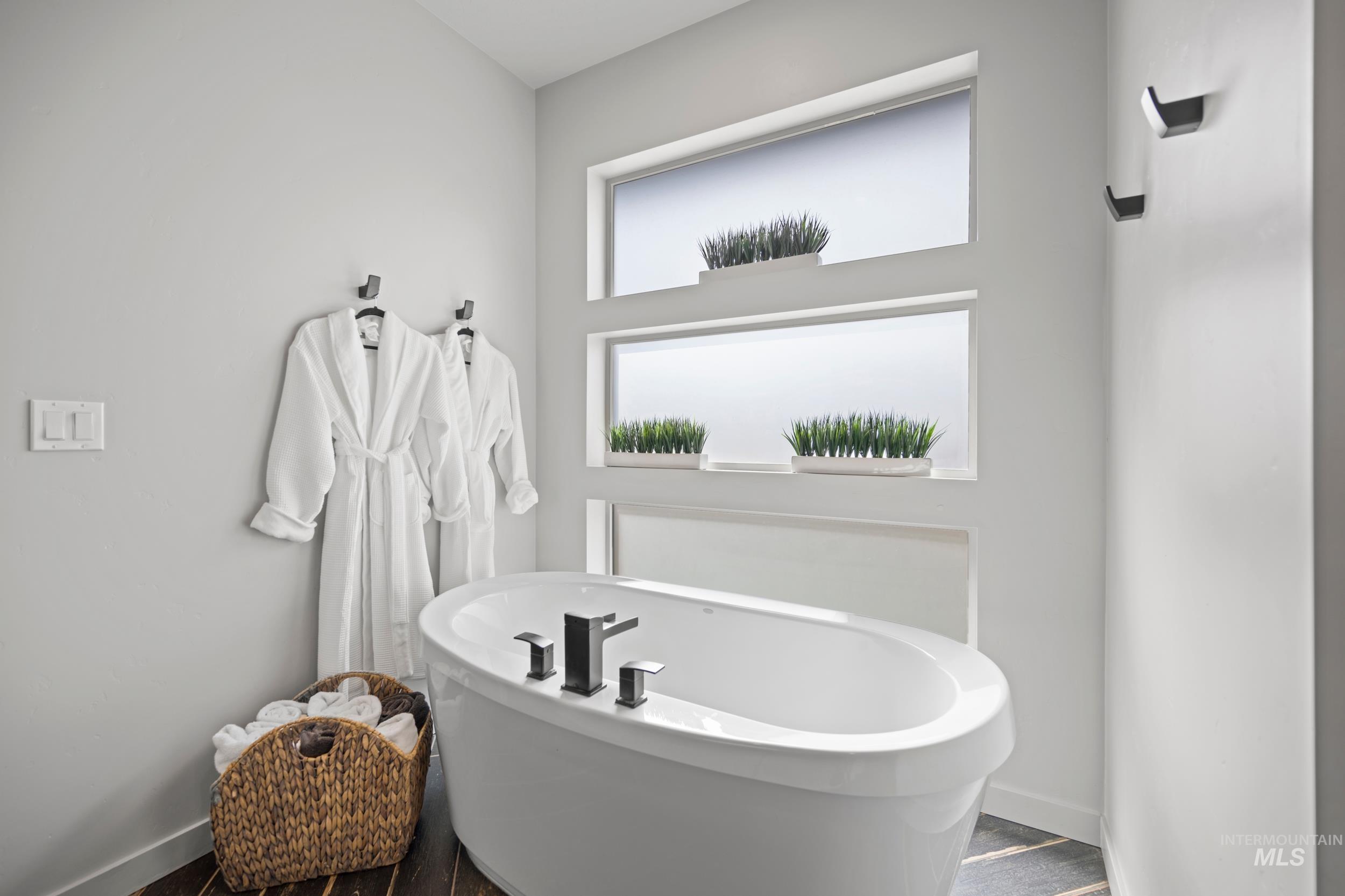 Full bathroom with a freestanding tub and wood finished floors