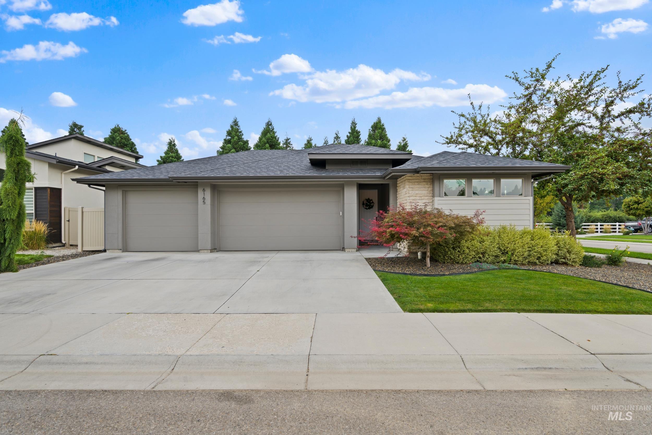 View of front of home featuring concrete driveway, roof with shingles, and an attached garage
