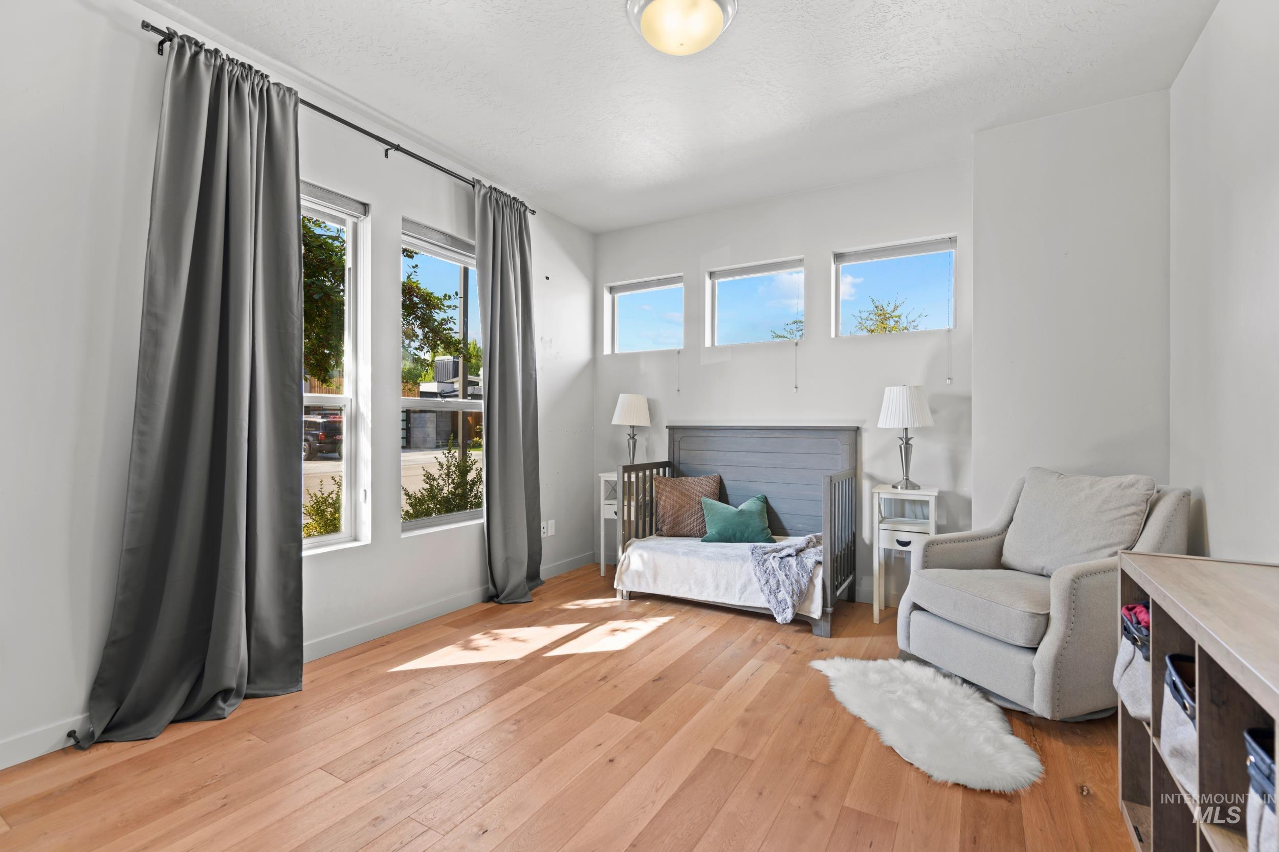 Sitting room featuring plenty of natural light, light wood-style flooring, and a textured ceiling