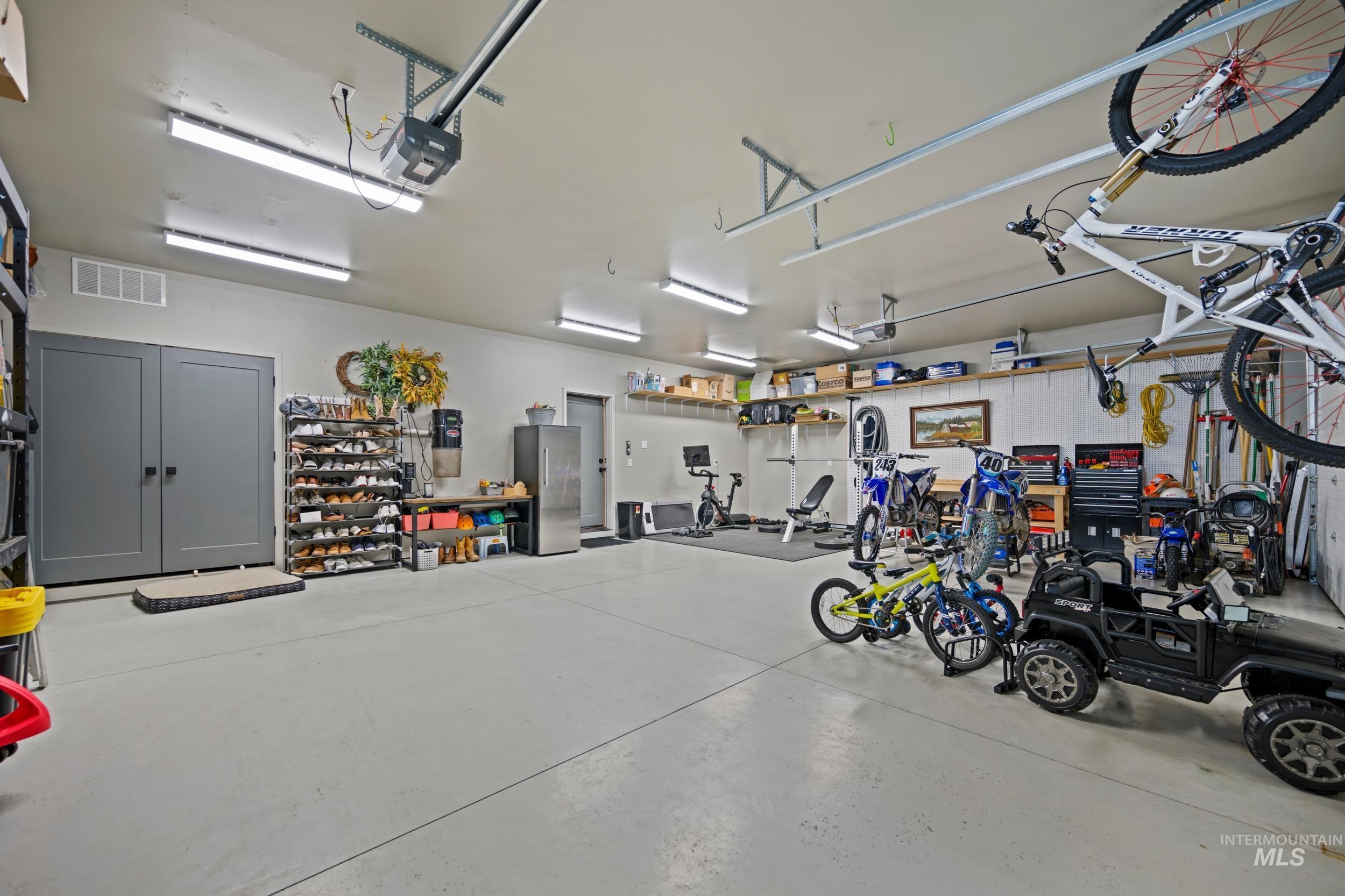 Garage with freestanding refrigerator and a garage door opener