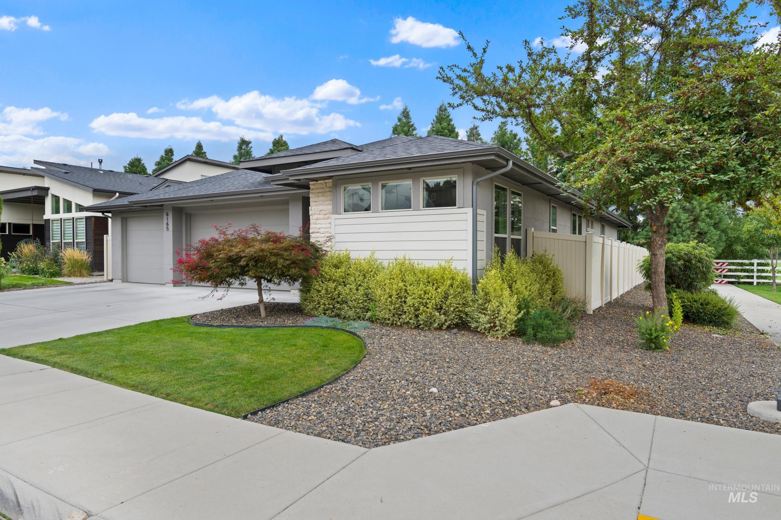 View of front of property featuring concrete driveway, a garage, and a shingled roof