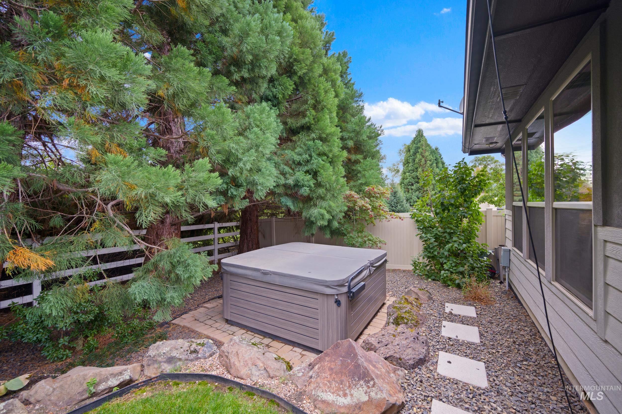 Fenced backyard with a hot tub