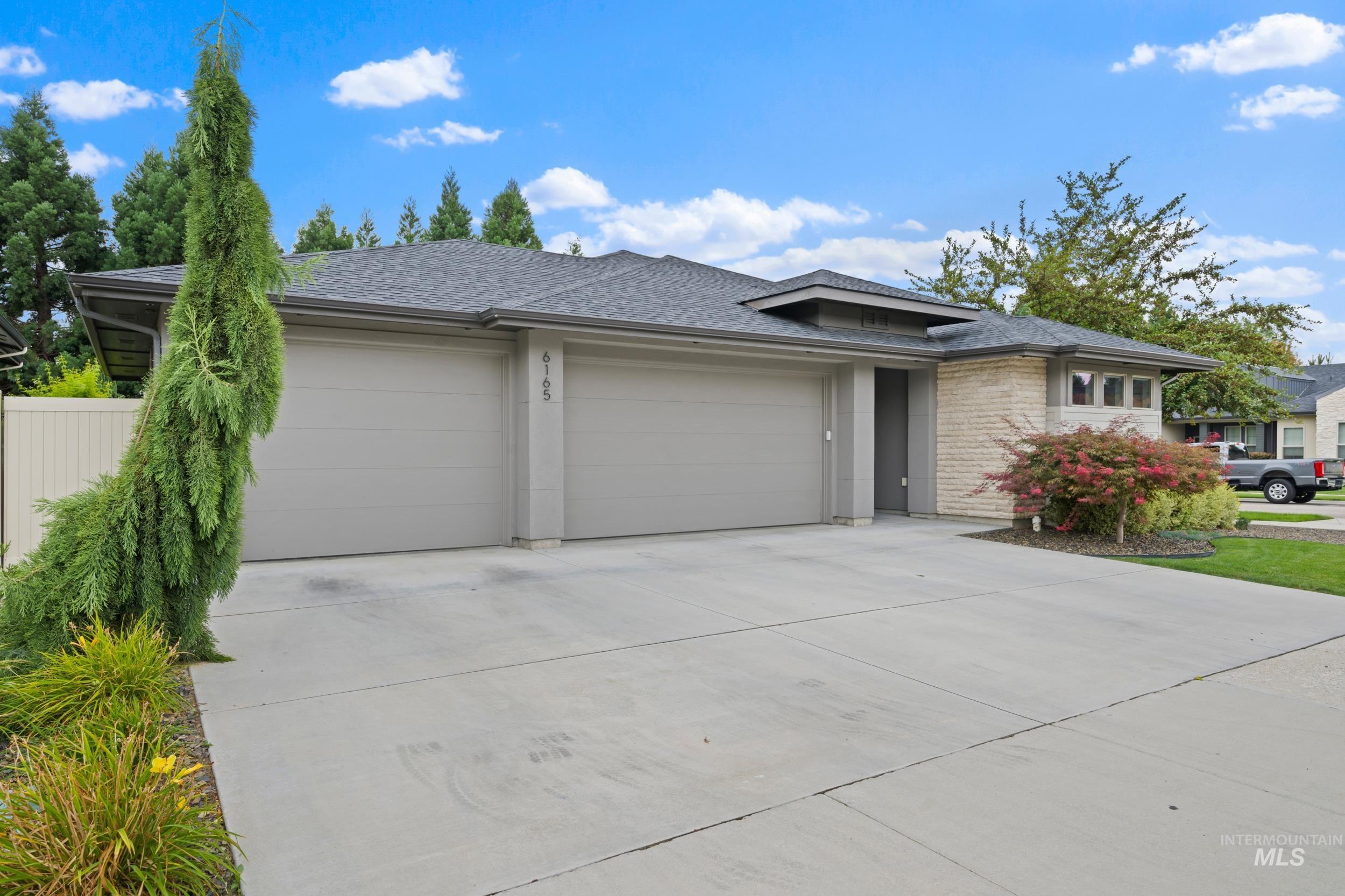 View of front of home featuring roof with shingles, a garage, and concrete driveway