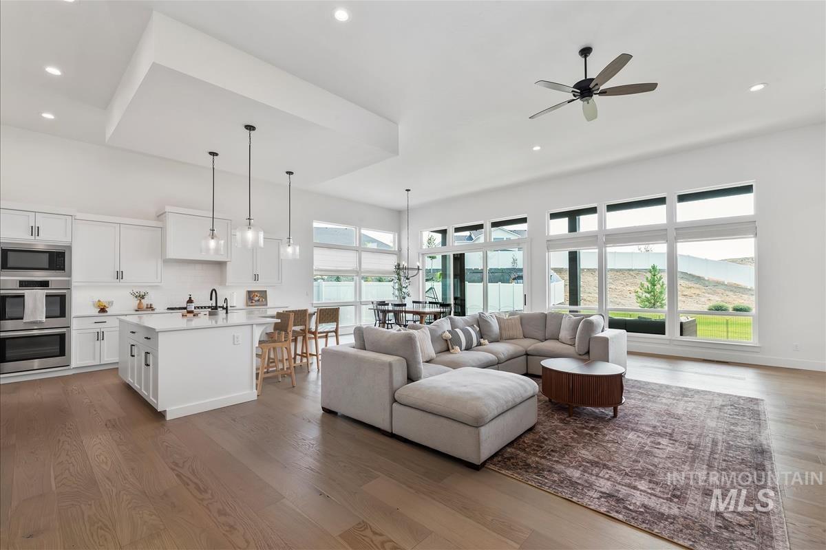 Living room with dark wood-type flooring, recessed lighting, and a ceiling fan