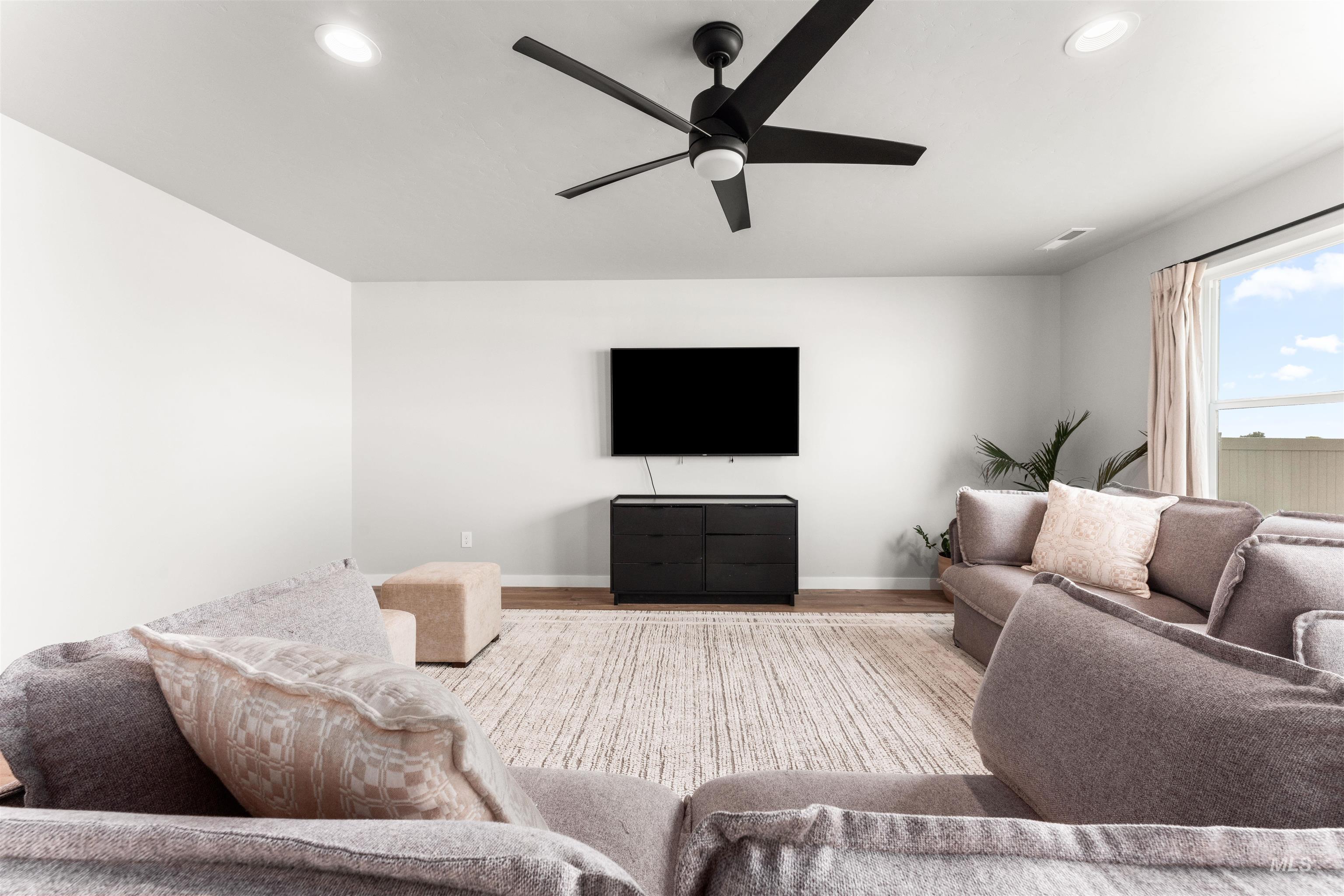 Living room featuring a ceiling fan, recessed lighting, and wood finished floors