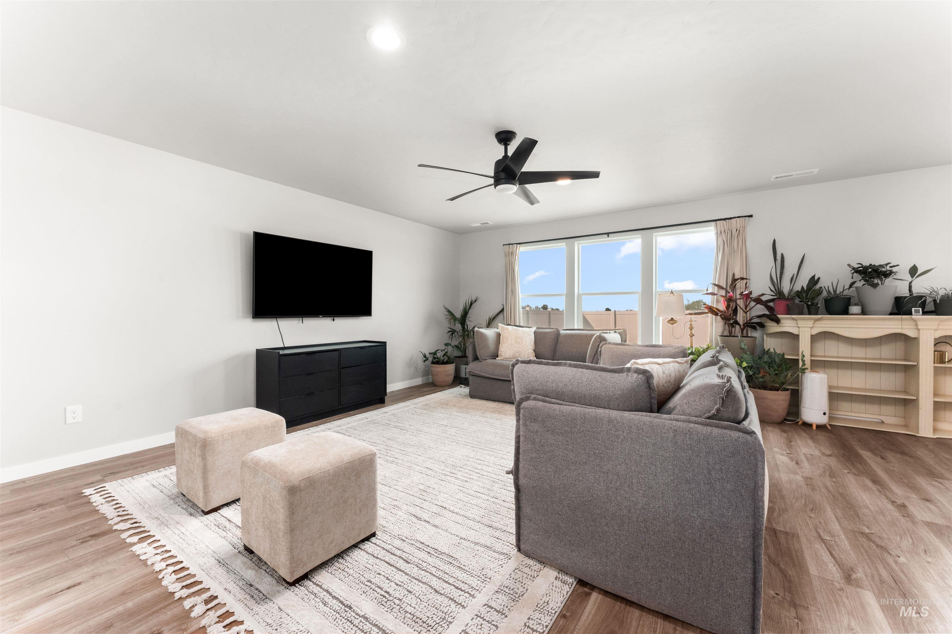 Living area featuring light wood-style floors and a ceiling fan
