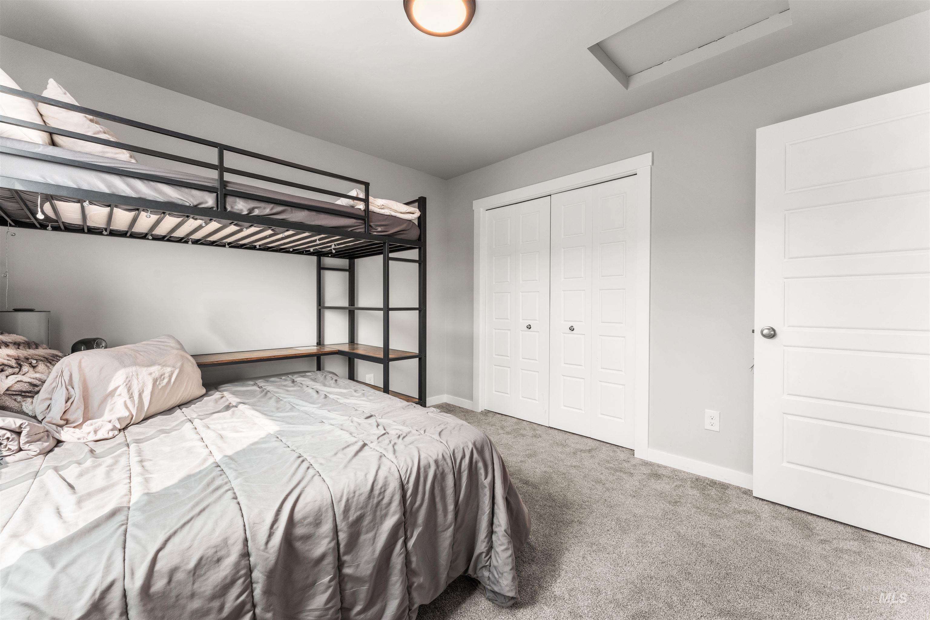 Carpeted bedroom featuring attic access and a closet