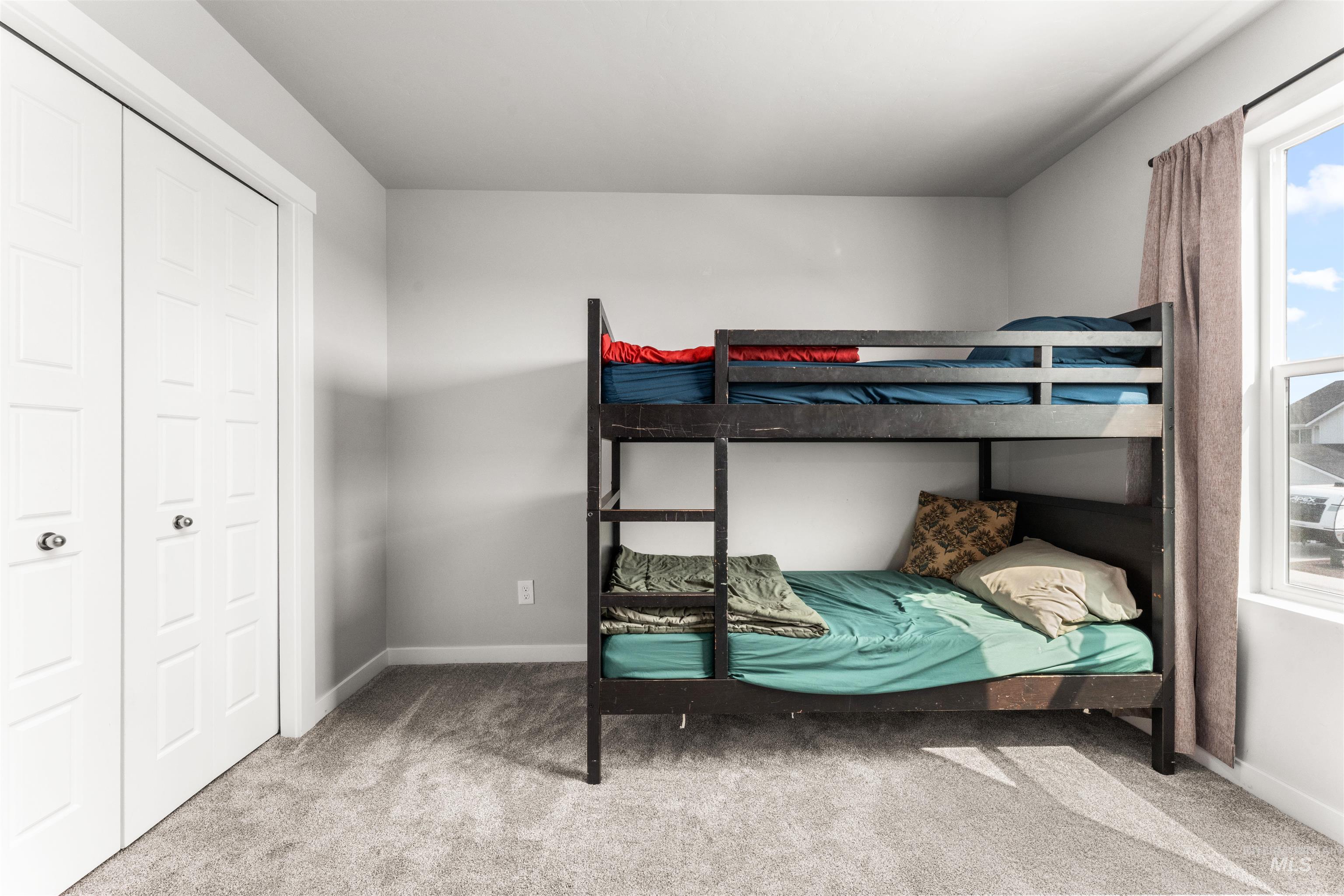 Bedroom featuring light carpet and a closet