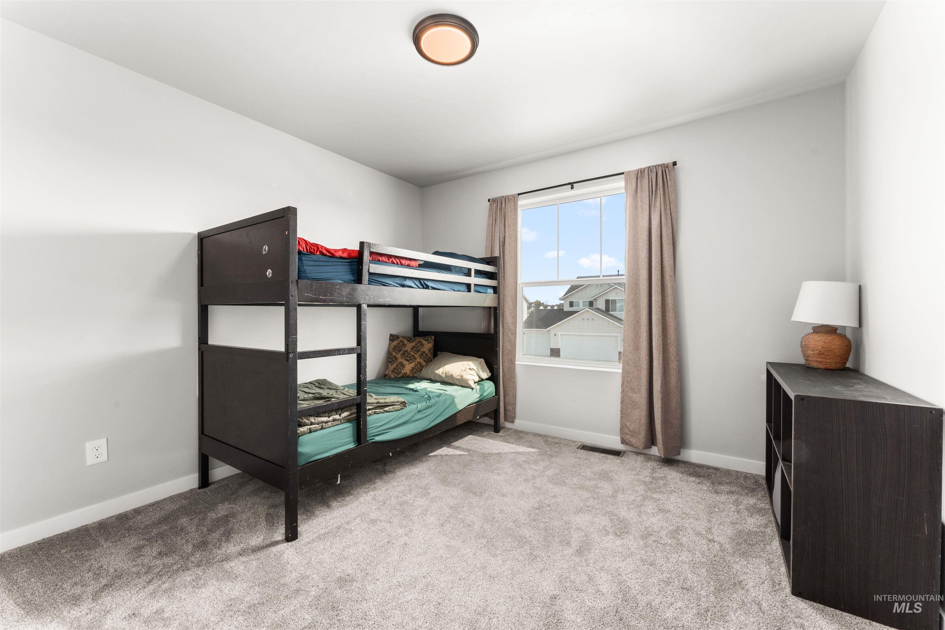 Bedroom with light carpet and baseboards