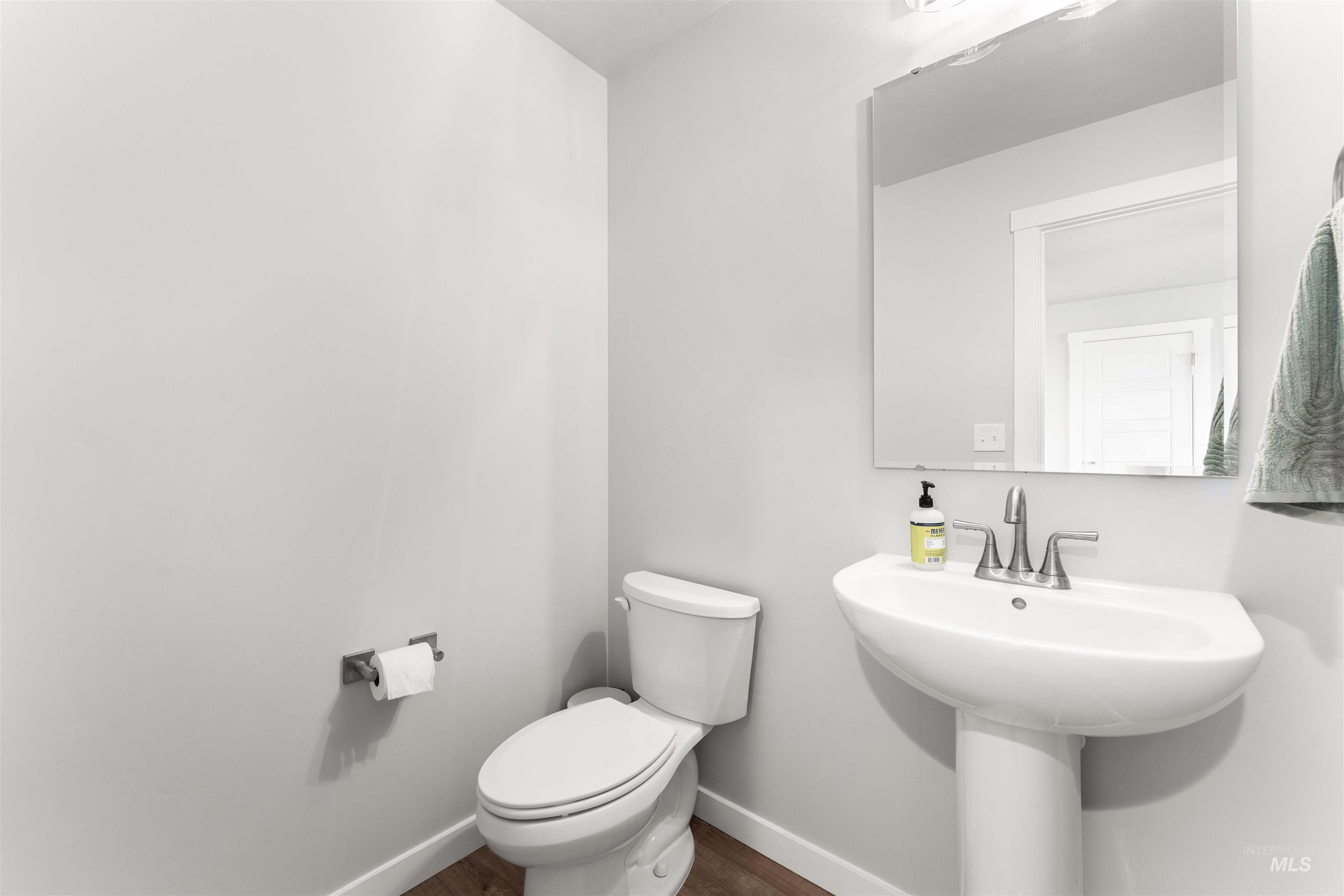 Bathroom featuring toilet and dark wood-type flooring