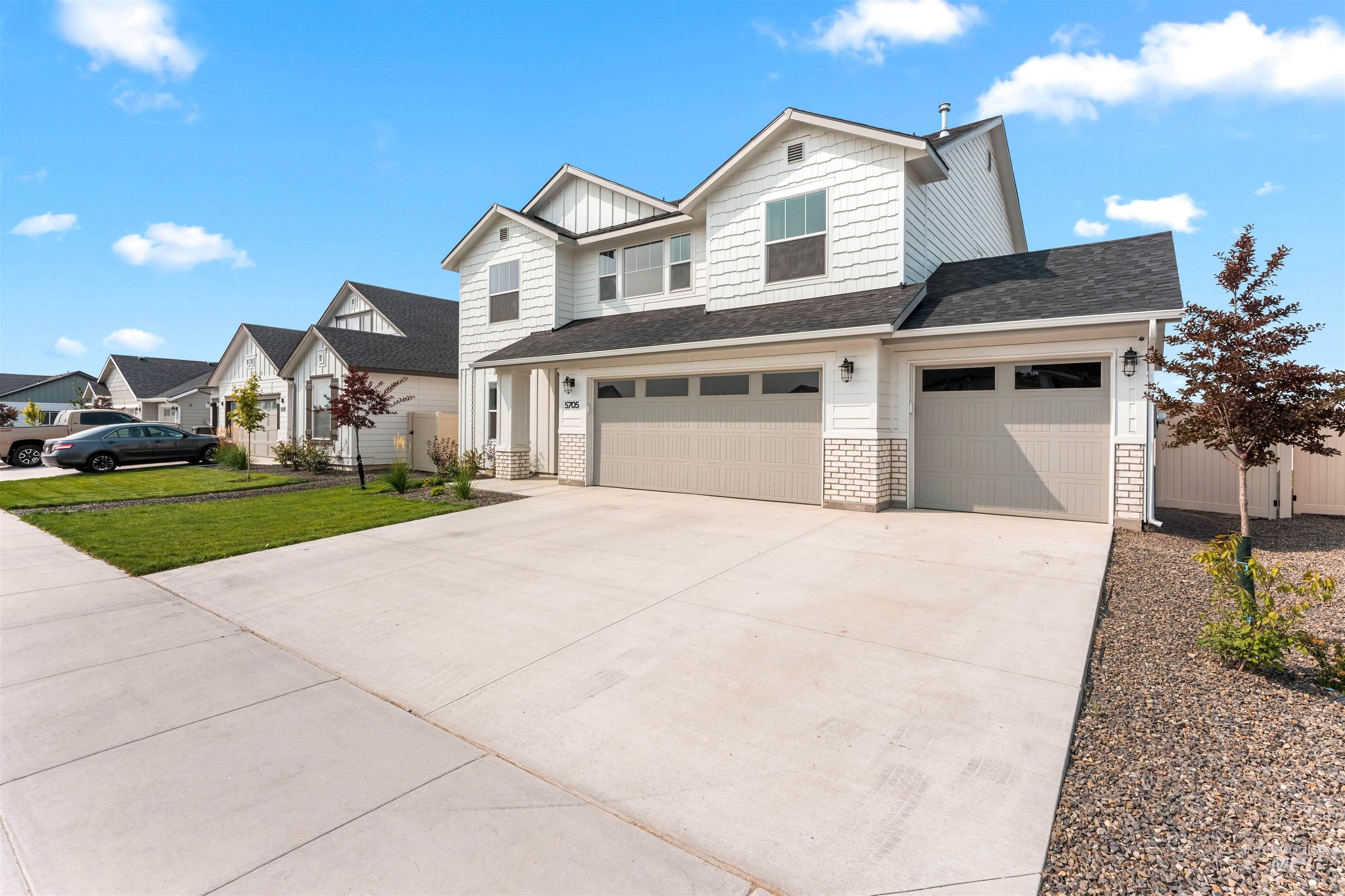 View of front of home featuring driveway, roof with shingles, an attached garage, and a residential view