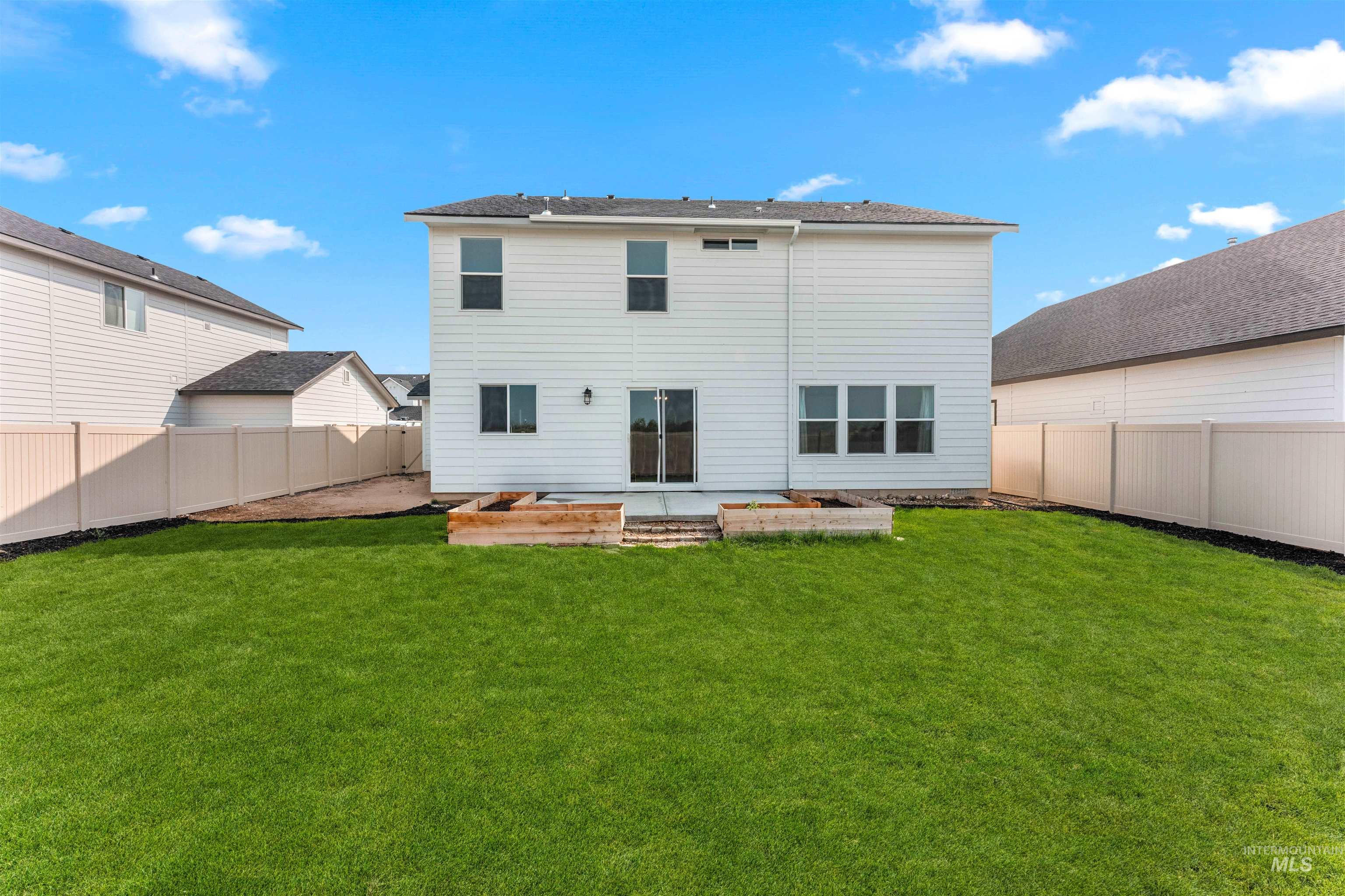 Rear view of property with a fenced backyard, a vegetable garden, and a patio area