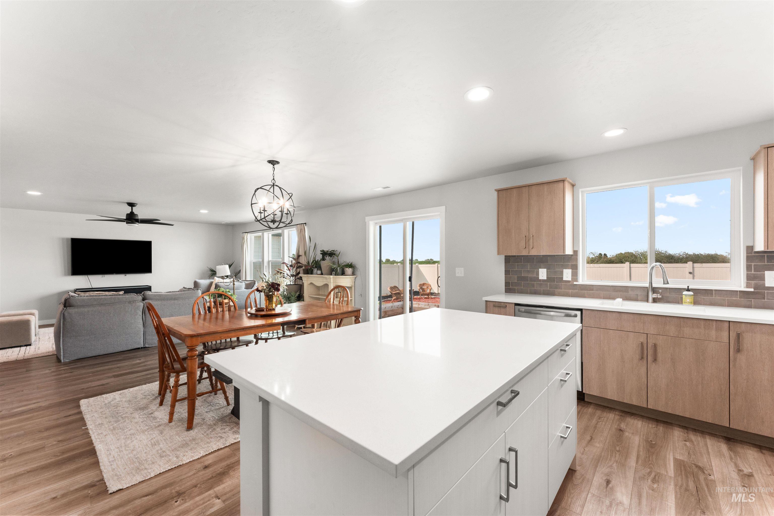 Kitchen featuring white cabinets, recessed lighting, plenty of natural light, decorative light fixtures, and light wood finished floors