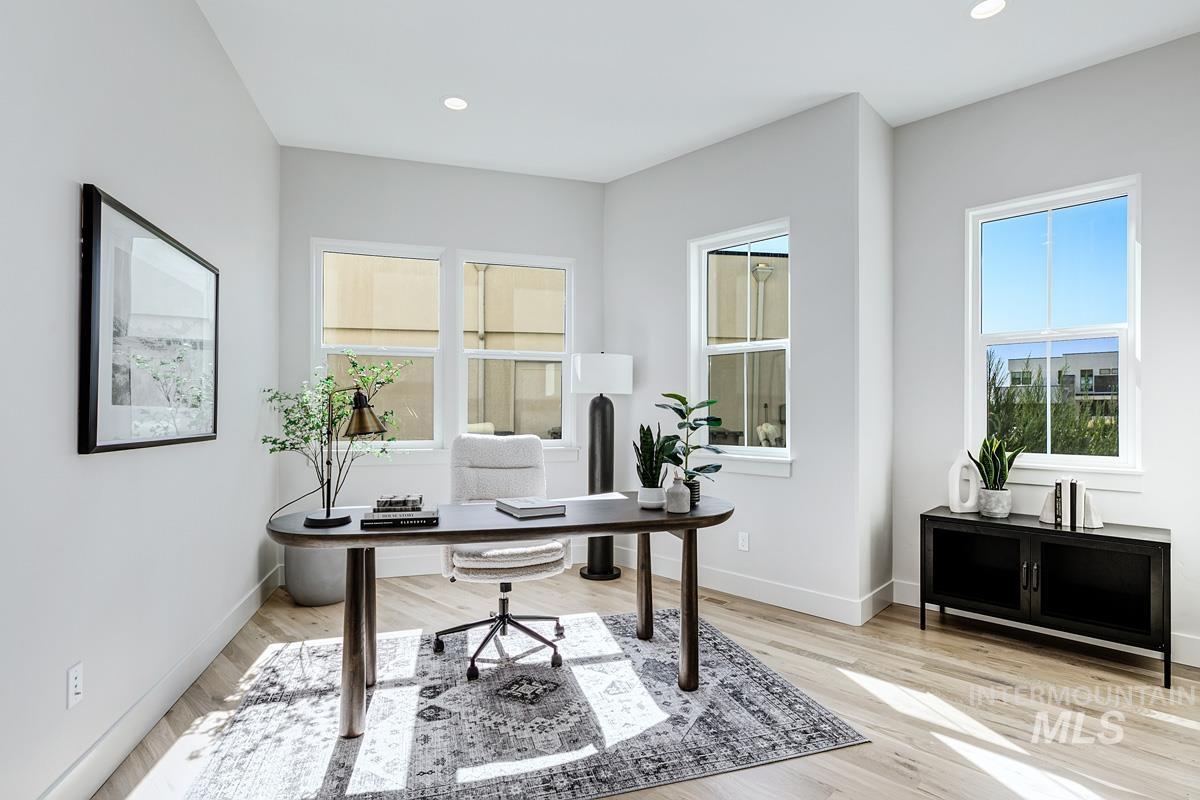 Office featuring healthy amount of natural light, light wood finished floors, and recessed lighting