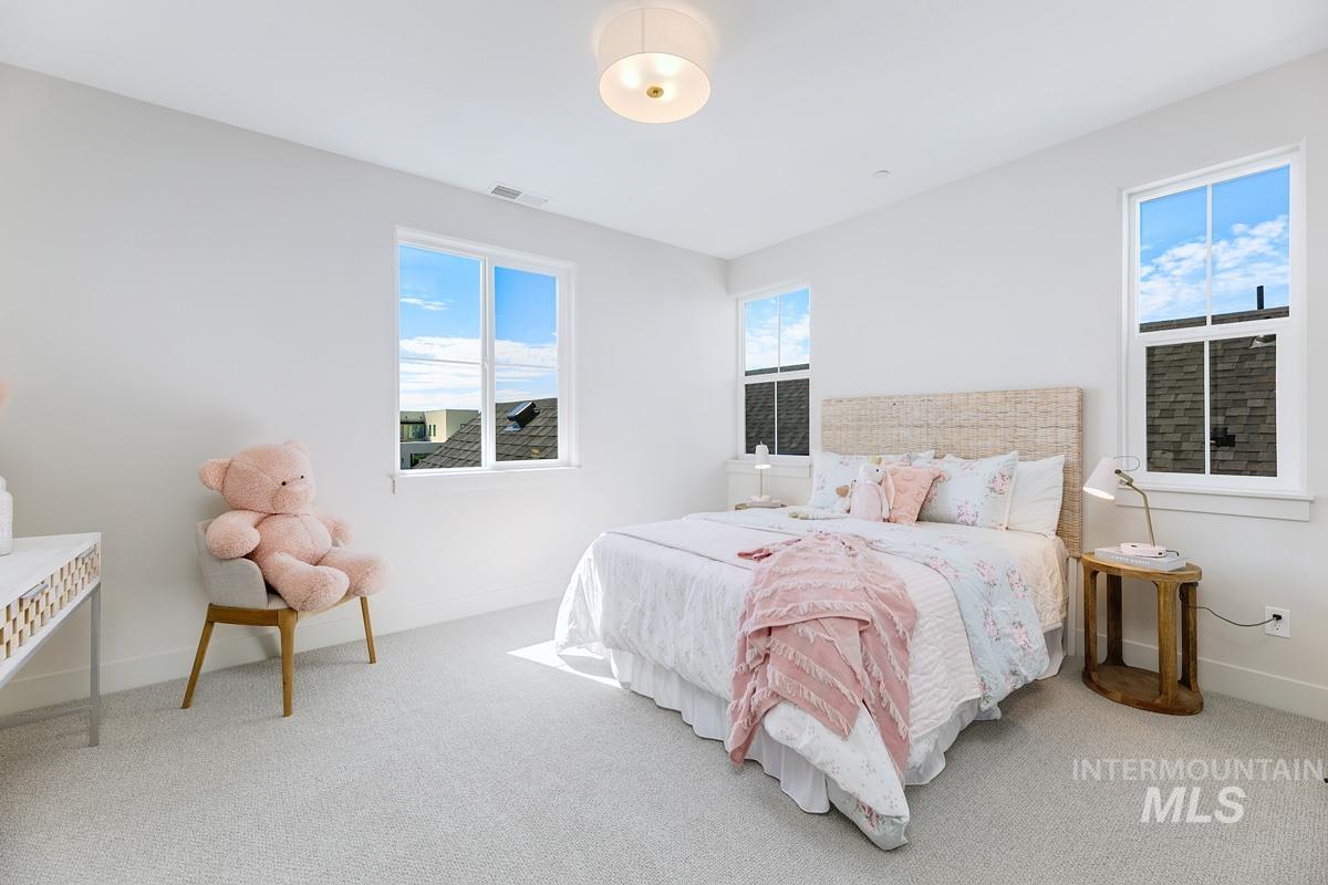 Bedroom featuring multiple windows and carpet flooring