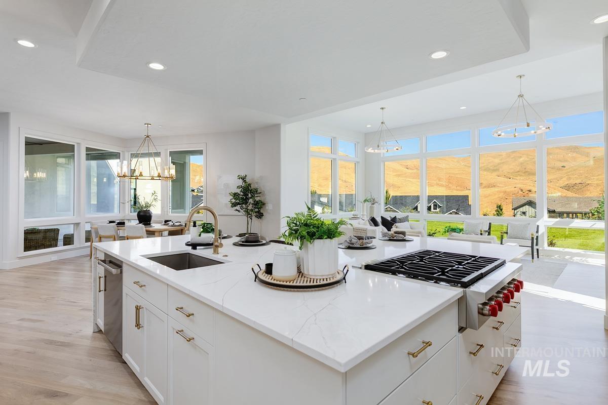 Kitchen with a chandelier, white cabinets, recessed lighting, decorative light fixtures, and light stone counters