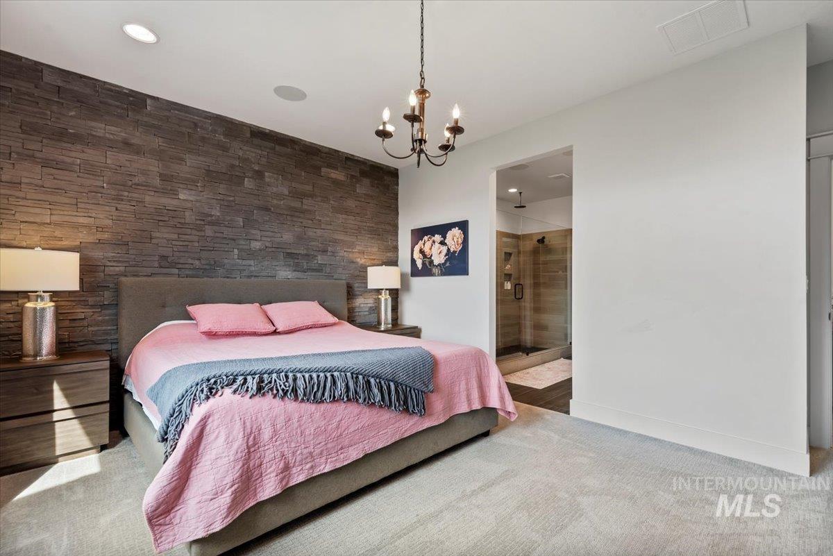 Carpeted bedroom featuring a chandelier, recessed lighting, and connected bathroom