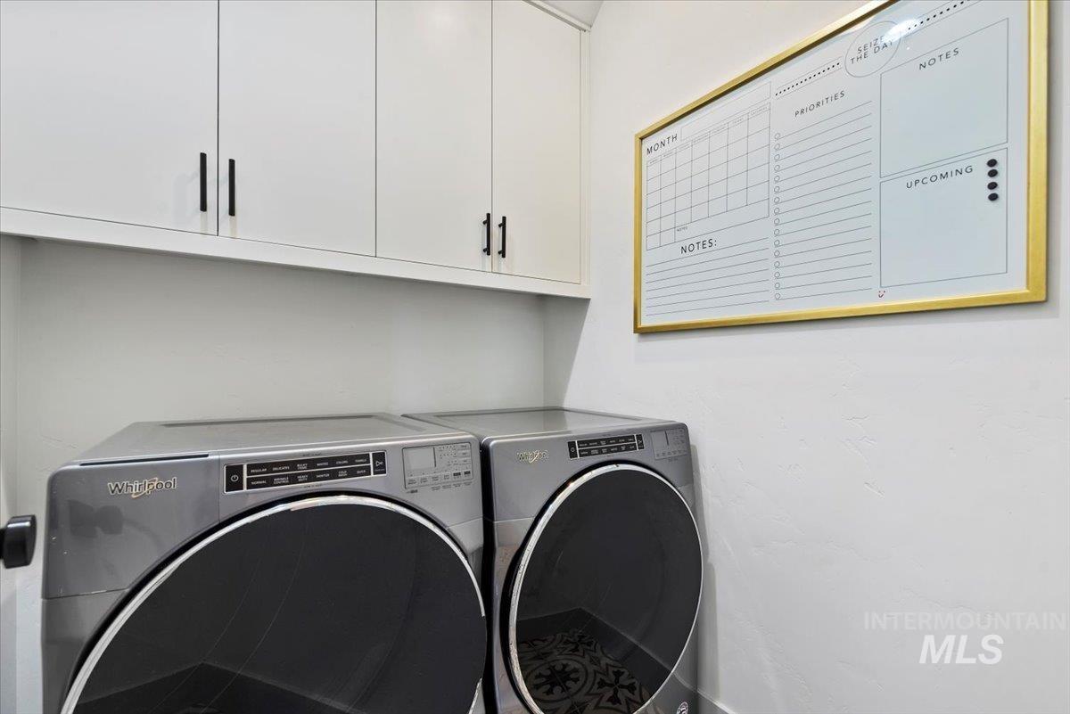 Laundry area featuring washer and clothes dryer and cabinet space