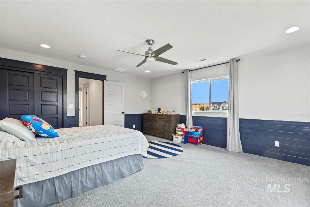 Bedroom with carpet, a ceiling fan, recessed lighting, wainscoting, and a closet