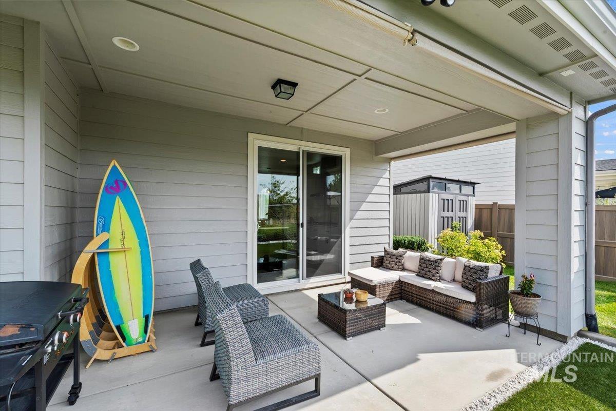 View of patio with an outdoor hangout area and a storage unit