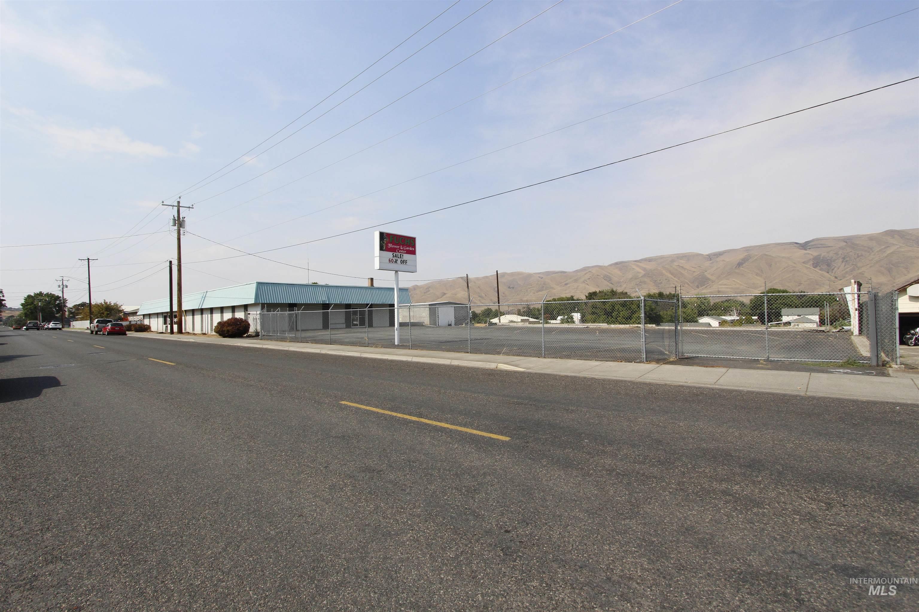 View of asphalt road featuring sidewalks and a mountain view