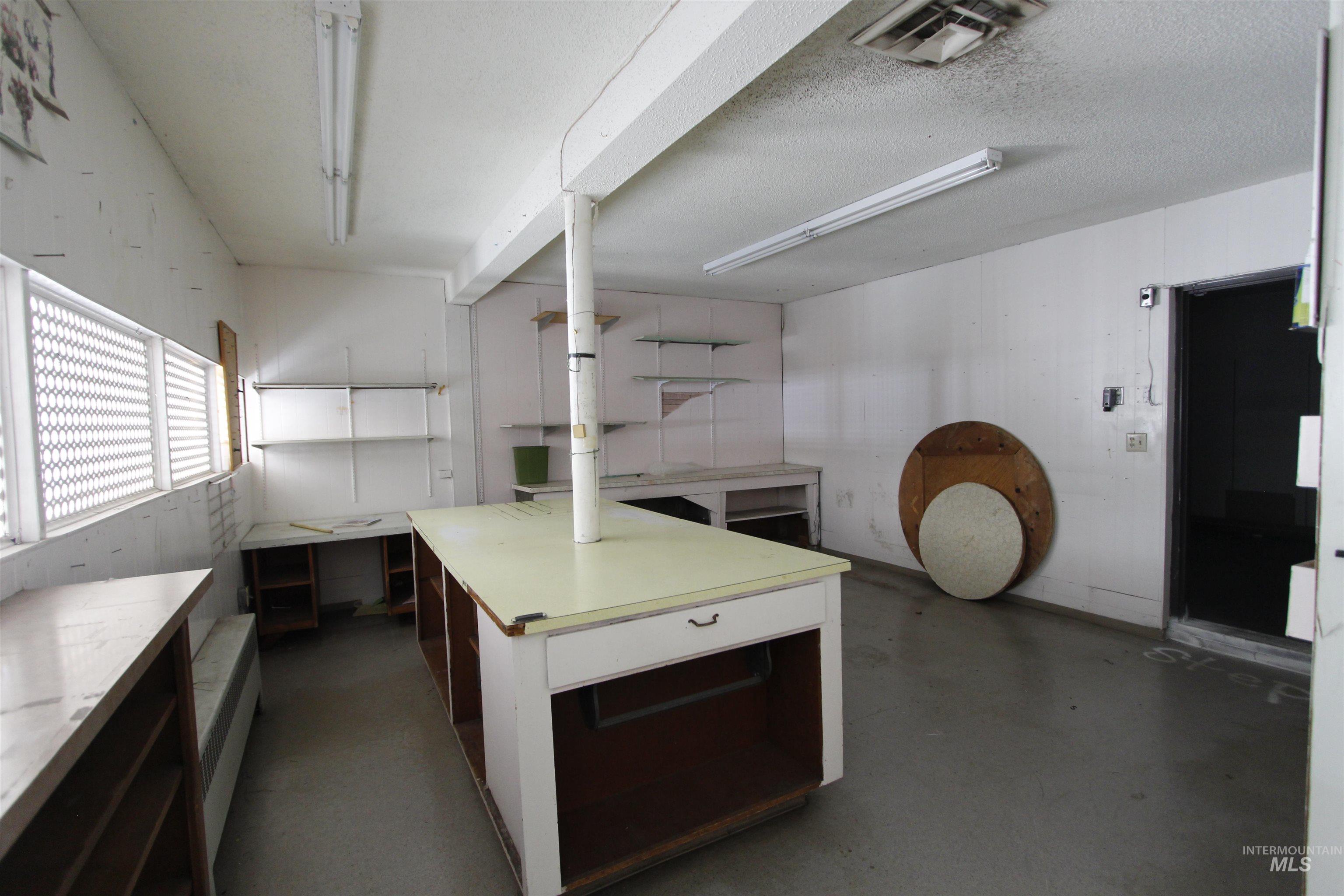 Kitchen featuring light countertops, concrete floors, and a textured ceiling