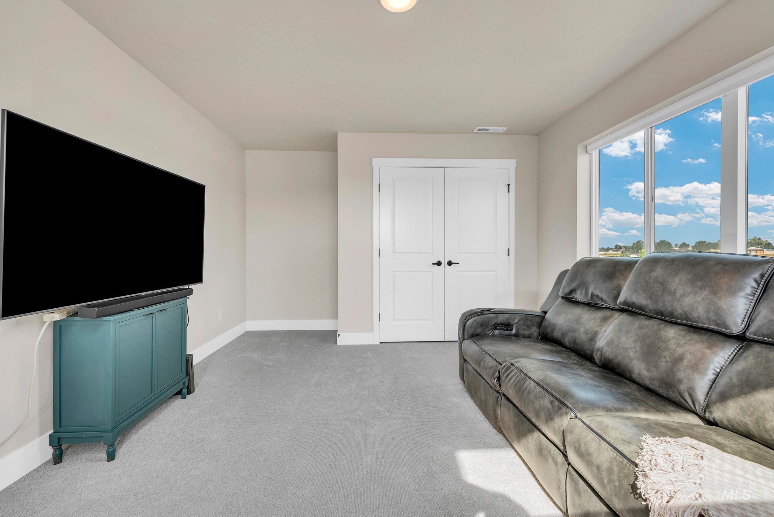 Carpeted living room featuring baseboards