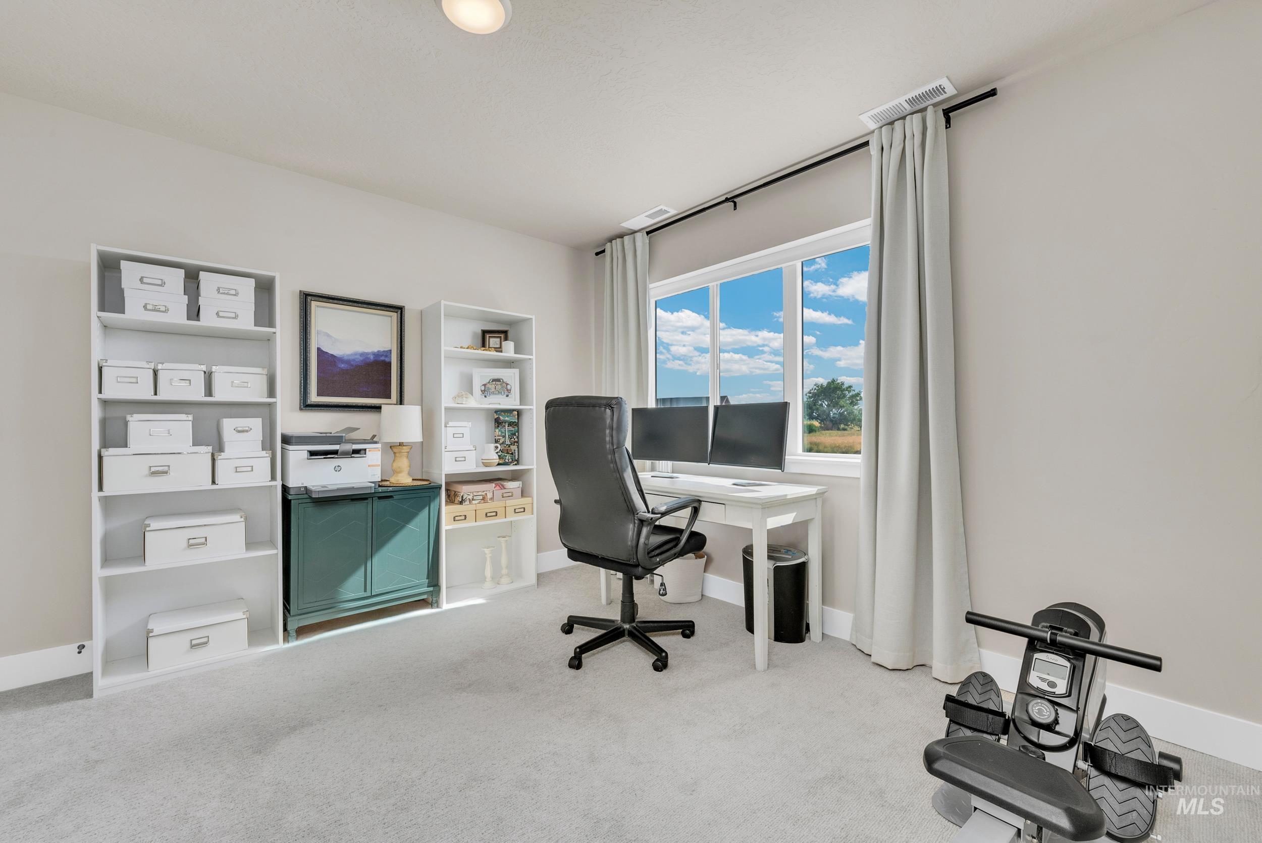 Office area featuring light carpet and baseboards