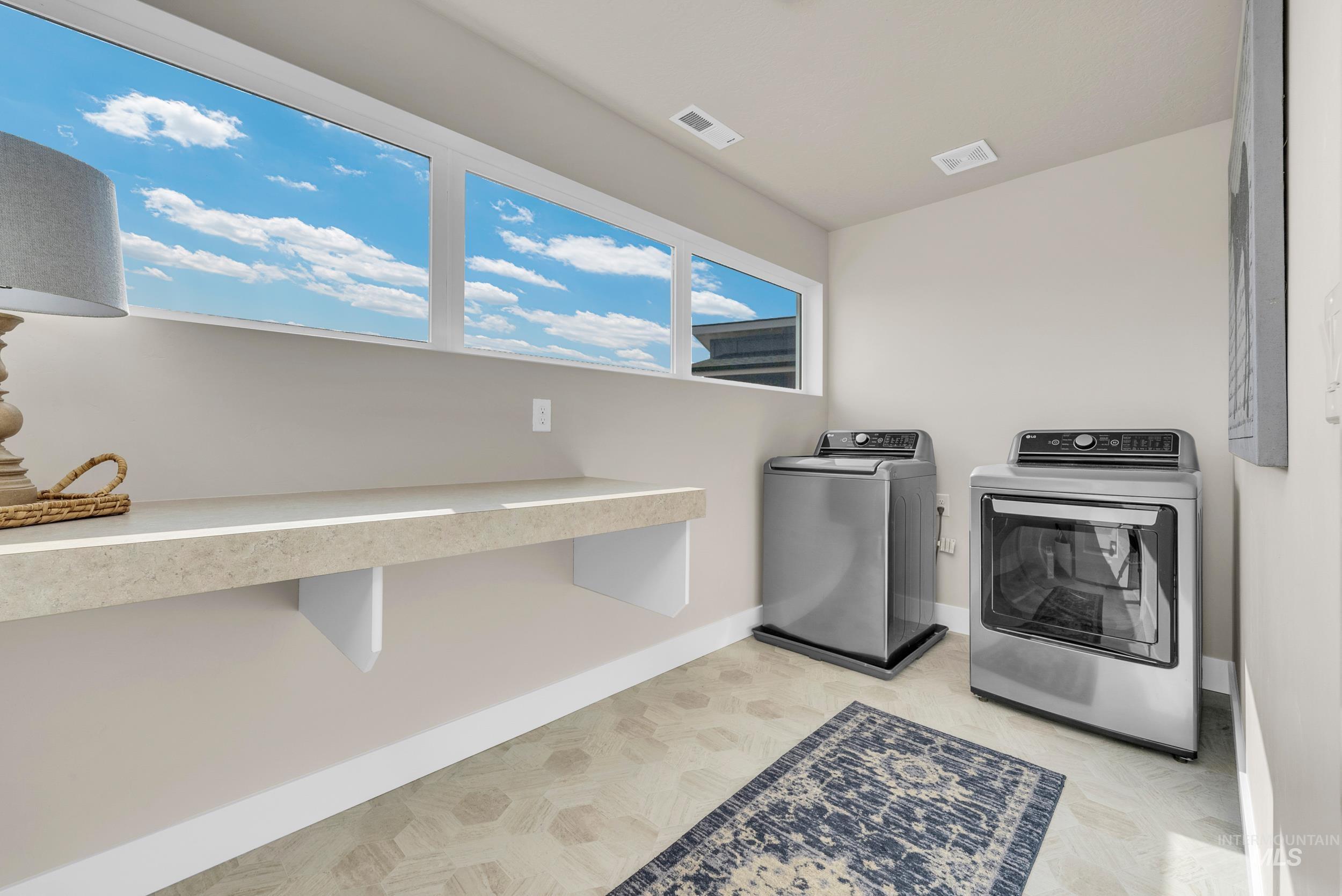 Washroom with baseboards and washing machine and clothes dryer