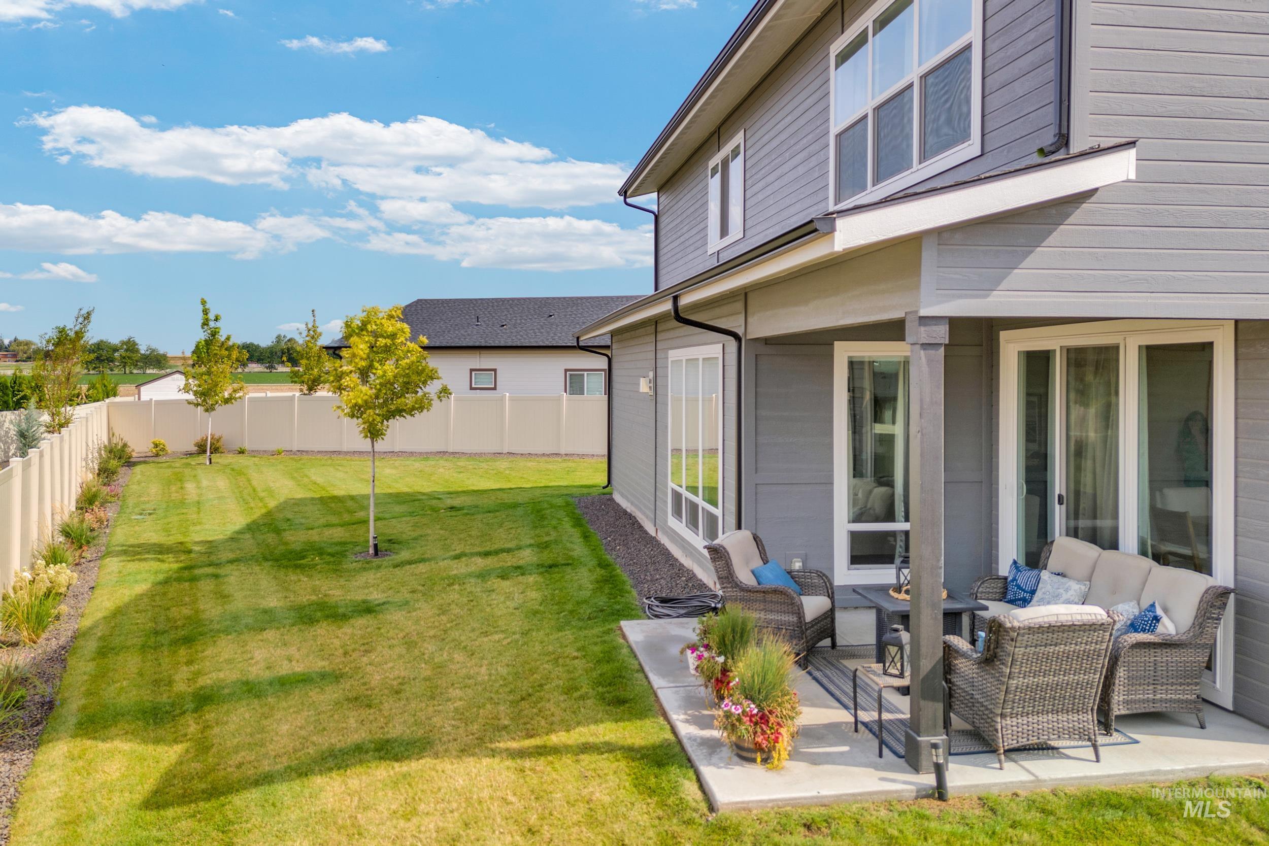 Fenced backyard featuring an outdoor hangout area and a patio