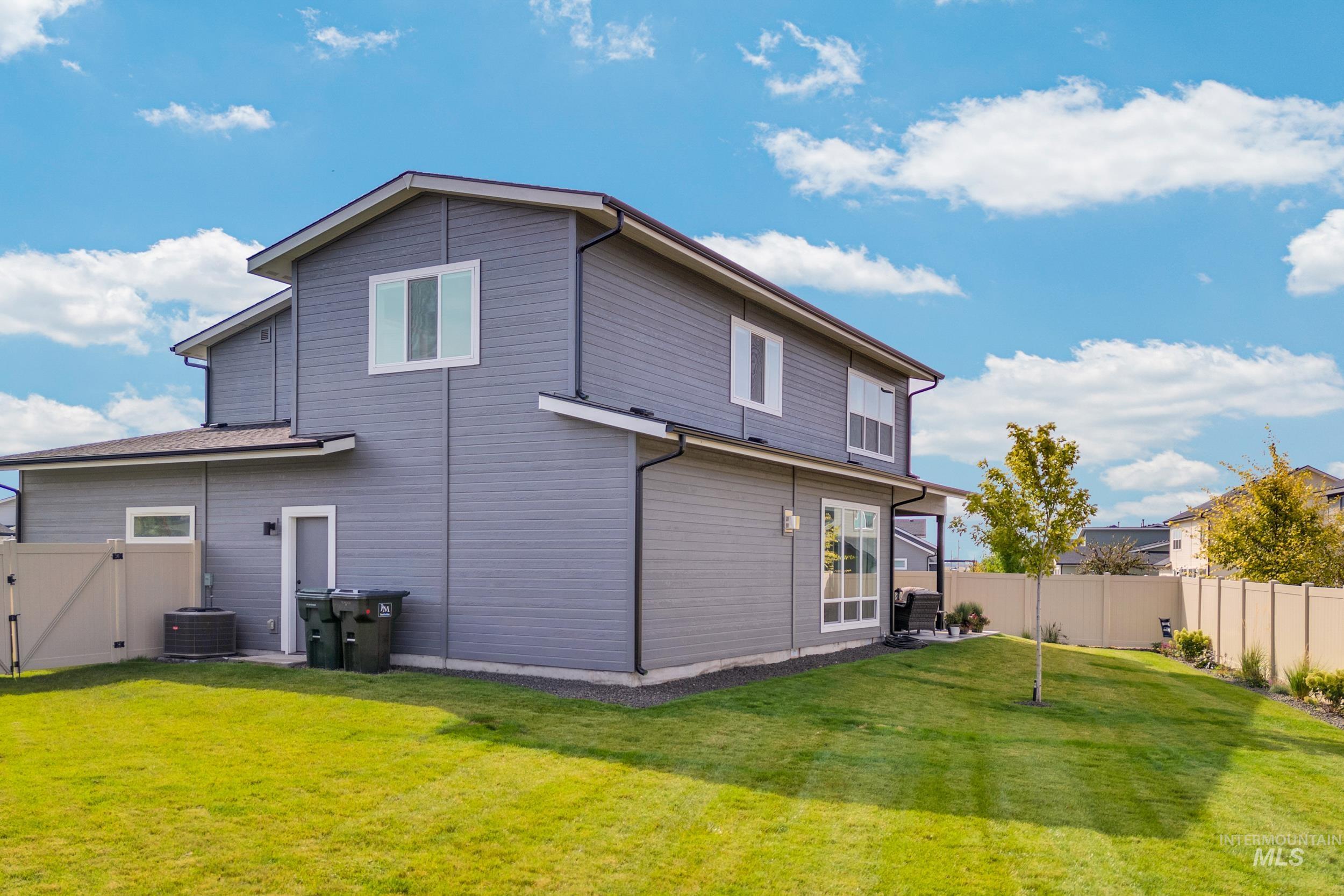Back of property with a fenced backyard and a gate