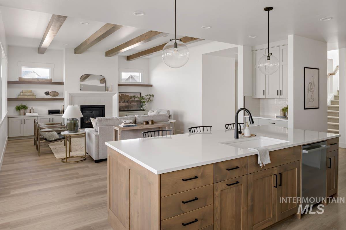 Kitchen with open floor plan, recessed lighting, an island with sink, hanging light fixtures, and stainless steel dishwasher