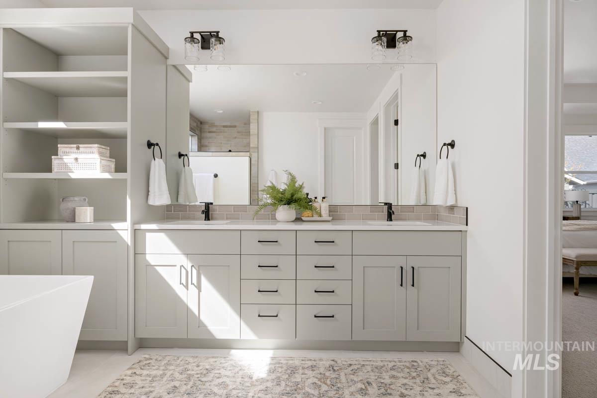 Ensuite bathroom featuring tasteful backsplash, a freestanding tub, double vanity, and a shower