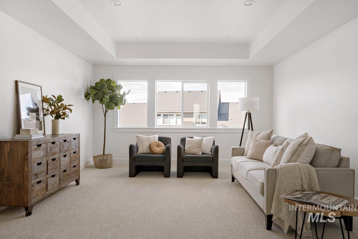 Sitting room with carpet floors and a tray ceiling