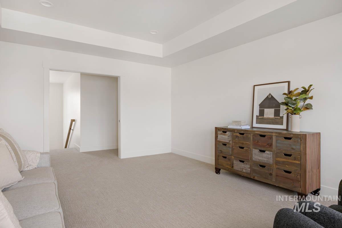 Sitting room featuring an upstairs landing and light carpet