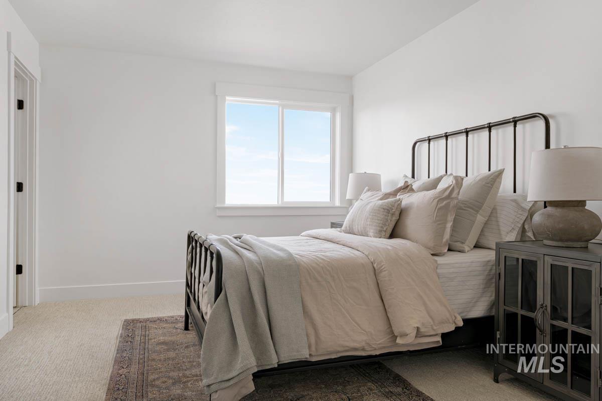 Bedroom featuring carpet flooring and baseboards