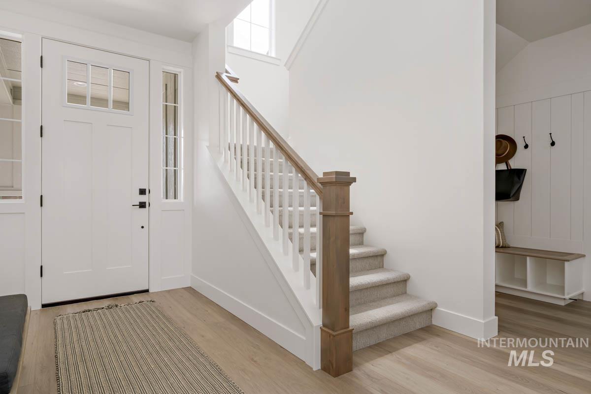 Entrance foyer with light wood-style floors and stairs